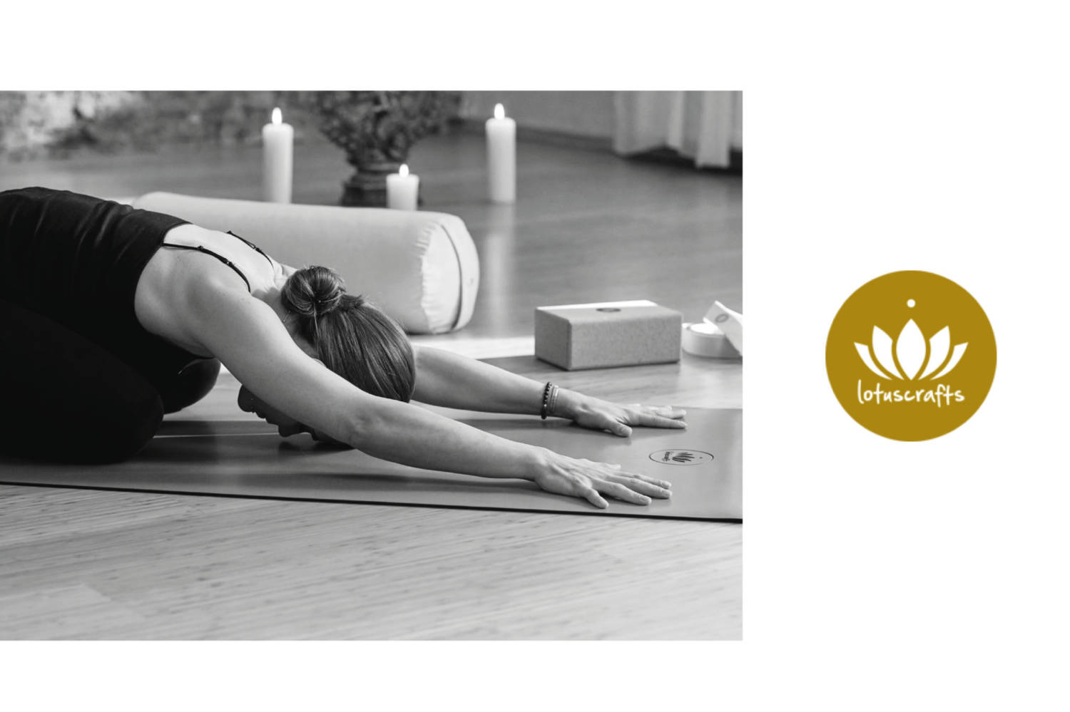 Eine Frau macht Yoga in der Kinderhaltung auf einer Matte, mit Meditationskissen und Kerzen im Hintergrund.