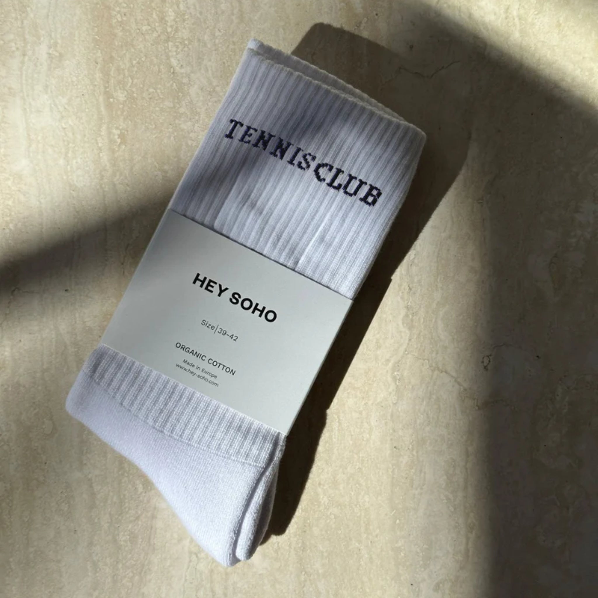 Weiße Socken mit "TENNIS CLUB"-Aufschrift, verpackt unter einem "HEY SOHO"-Label, aus Bio-Baumwolle, Größe 39-42.