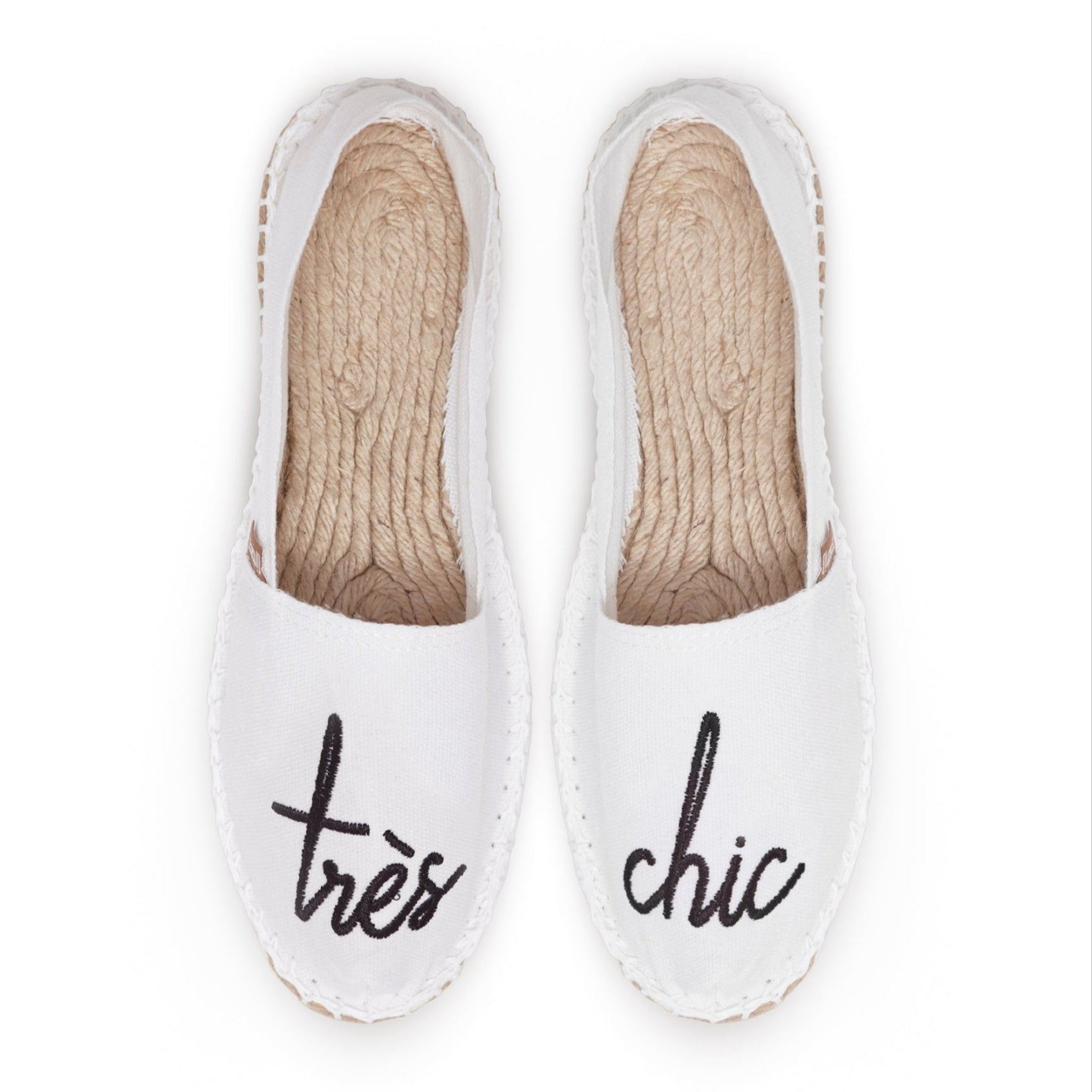 Weiße Espadrilles mit Aufschrift "très chic" in schwarzer Schrift auf den Zehen.