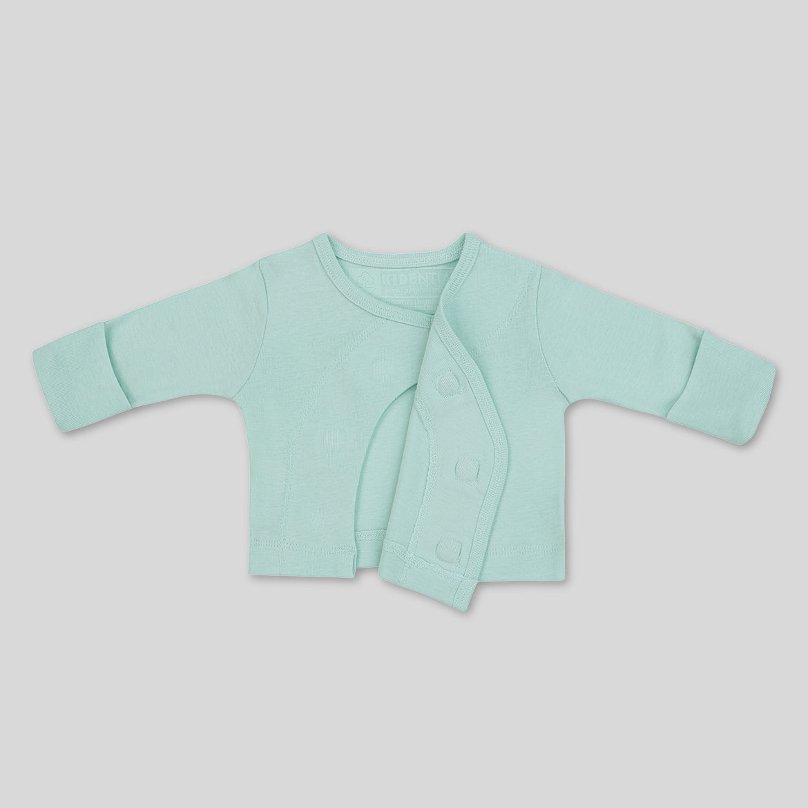 Hellblaues Babyjäckchen mit langen Ärmeln, asymmetrisch geöffnet, aus weichem Stoff auf grauem Hintergrund.