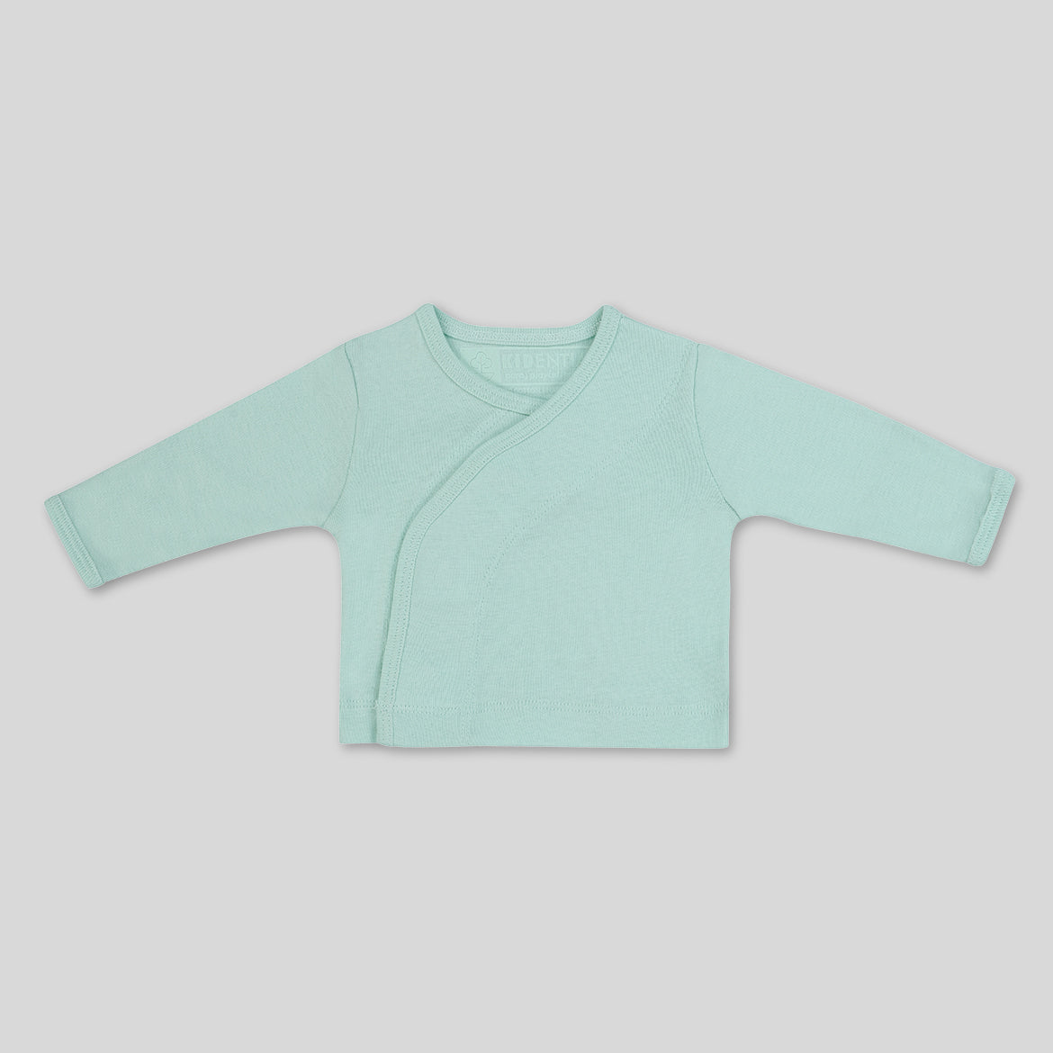 Mintgrünes Babyjäckchen mit langen Ärmeln und seitlicher Knopfleiste, auf grauem Hintergrund präsentiert.