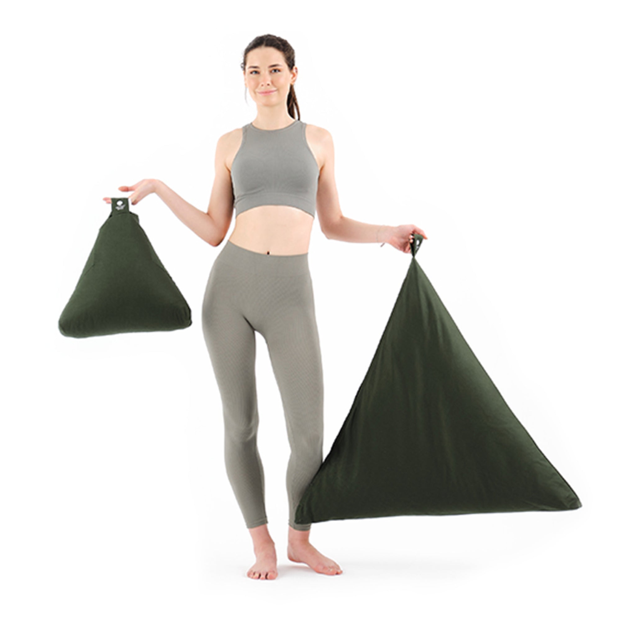 Eine Frau in Sportbekleidung hält zwei dreieckige, grüne Taschen unterschiedlicher Größe in den Händen.