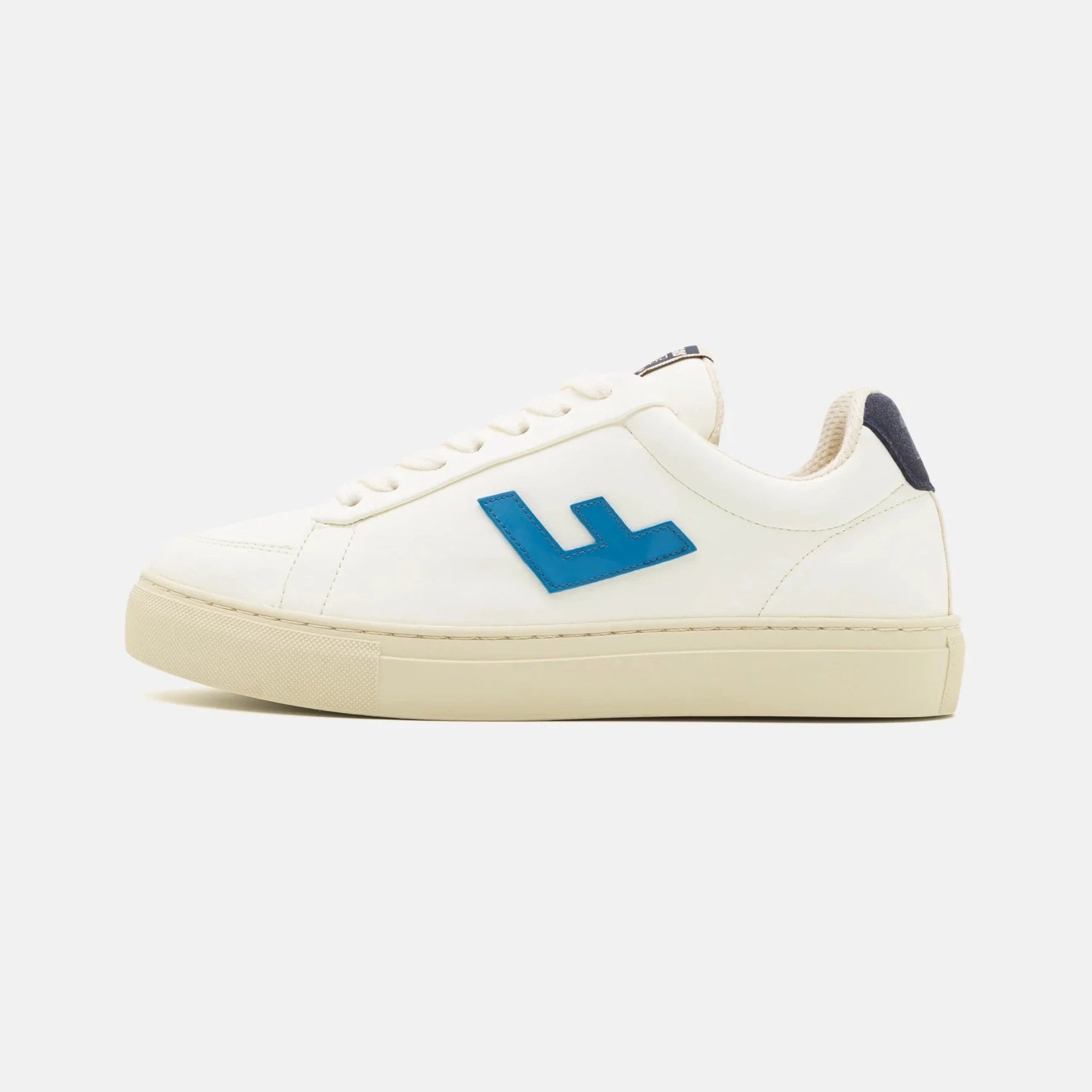 Weißer Sneaker mit cremefarbener Sohle und blauem "L"-Logo auf der Seite, vor weißem Hintergrund.