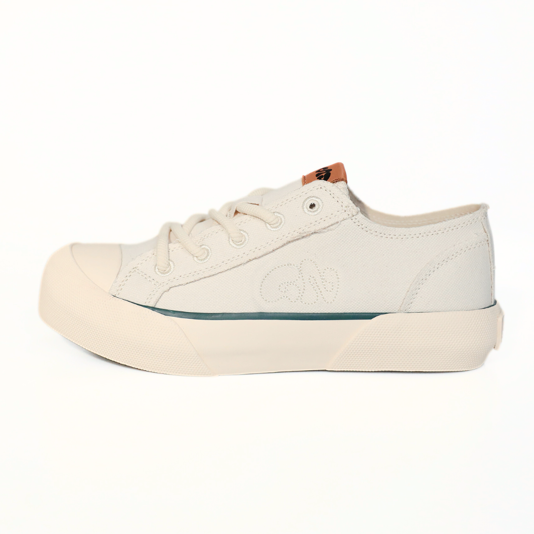 Beiger, lässiger Sneaker mit flacher Sohle, Schnürung und gesticktem Logo an der Seite, auf weißem Hintergrund.