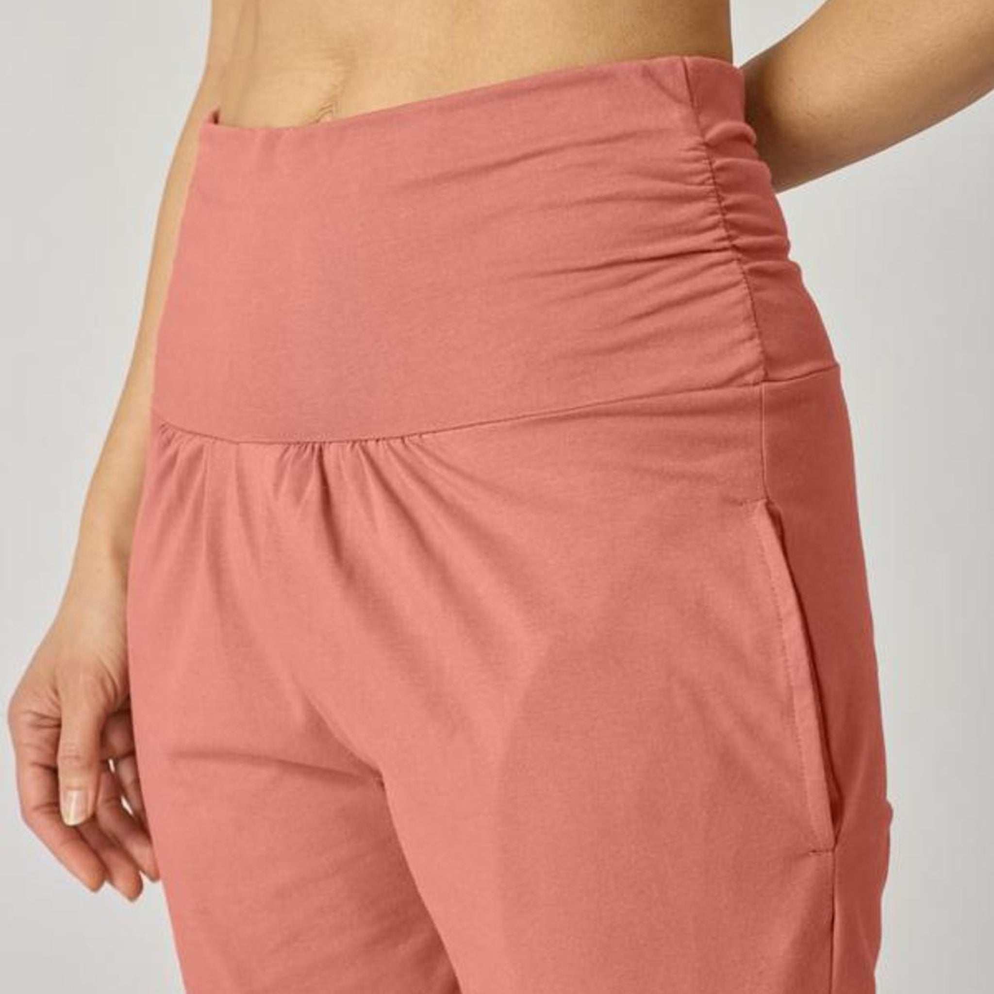 Nahaufnahme eines Models in rosa High-Waist-Hose, die aus einem Stretchstoff gefertigt ist.