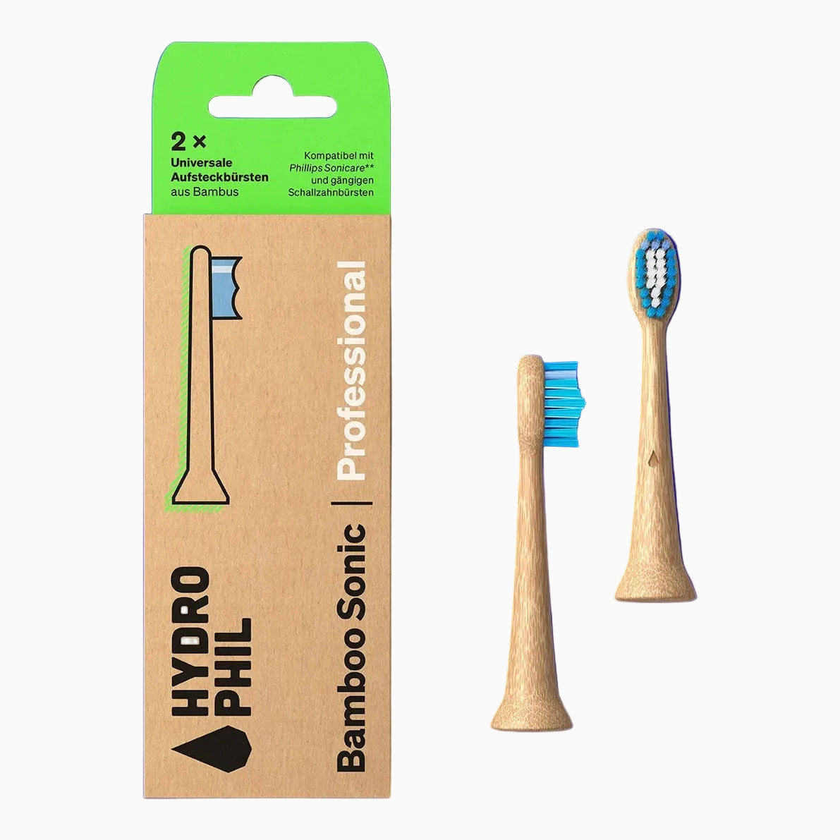 Eine Pappschachtel mit der Aufschrift HYDROPHIL Bamboo Sonic Professional mit zwei Bambuszahnbürstenköpfen, von denen einer aufrecht steht und einer flach liegt, auf einem hellblauen Hintergrund.