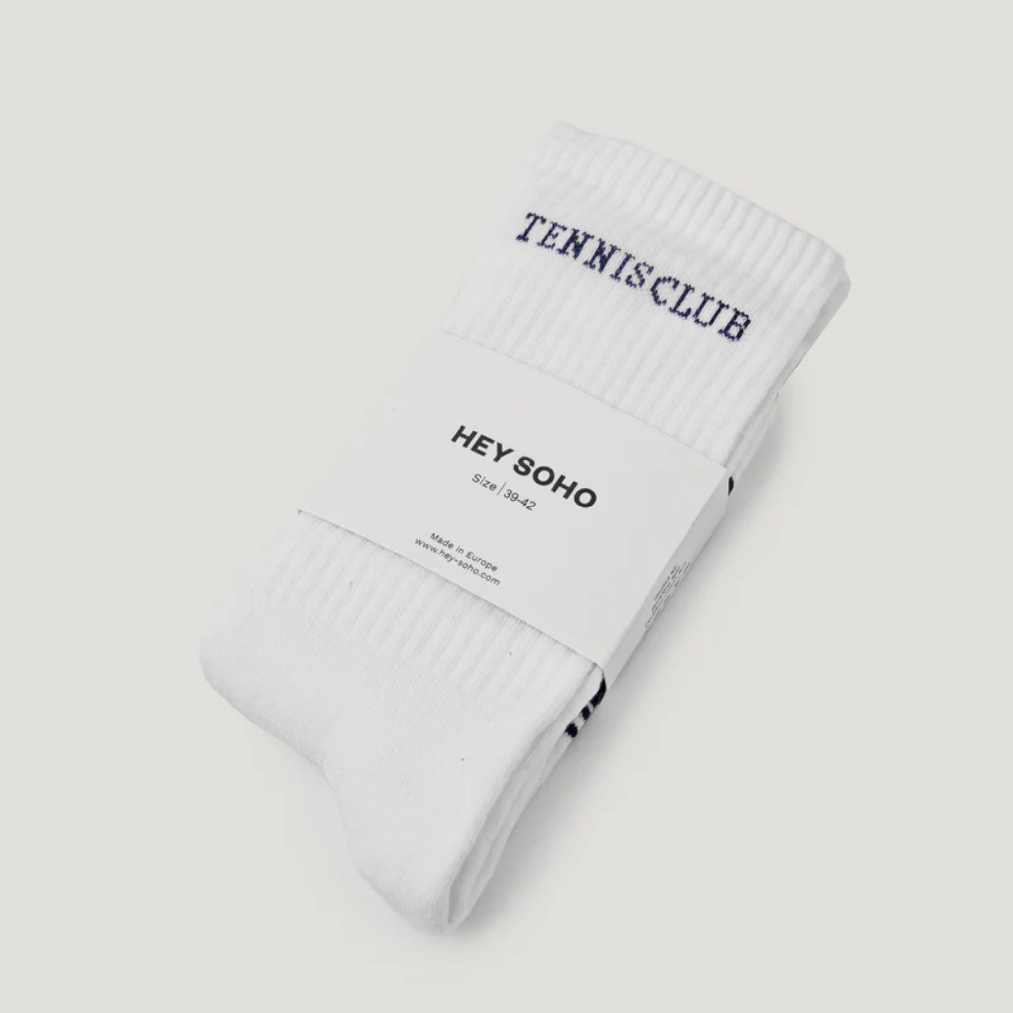 Weiße Tennissocken mit der Aufschrift "TENNIS CLUB", verpackt mit einem Etikett von "HEY SOHO", Größe 39-42.