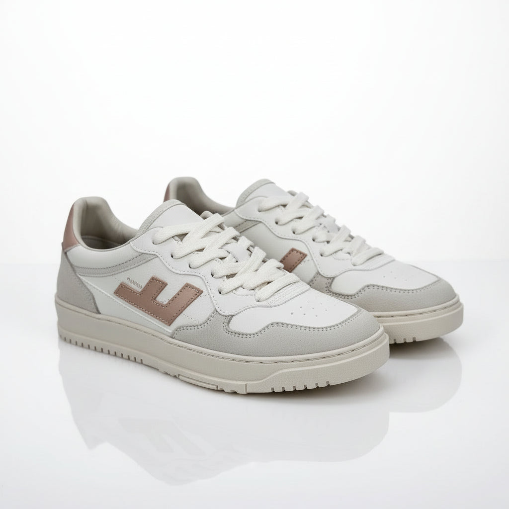 Ein Paar weiße und beigefarbene Turnschuhe mit hellbraunen Akzenten und Schnürsenkeln, mit einem stilisierten L-Logo an der Seite, das auf einer grauen Oberfläche platziert ist.