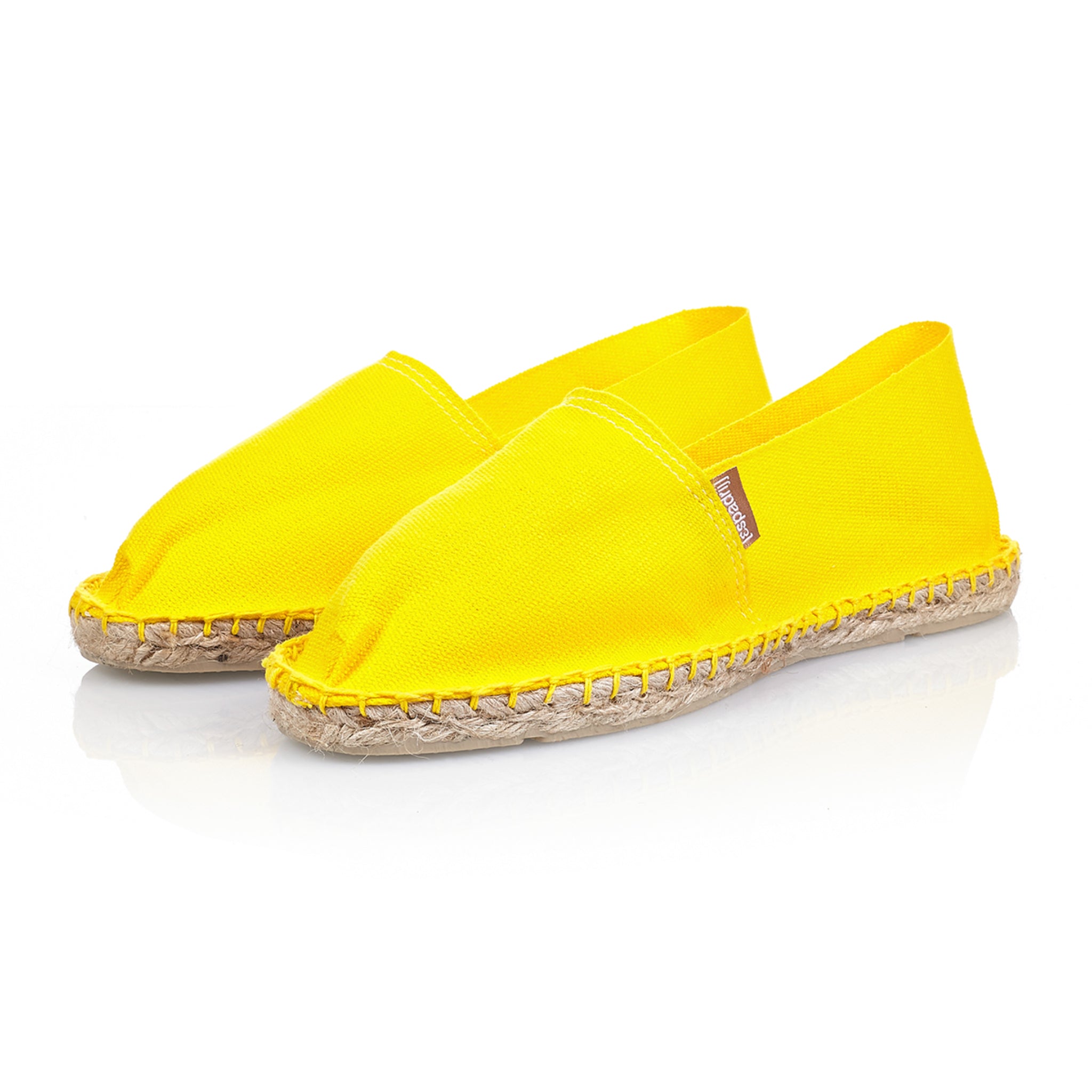 Ein Paar gelbe Espadrilles mit Jutesohlen auf weißem Hintergrund.