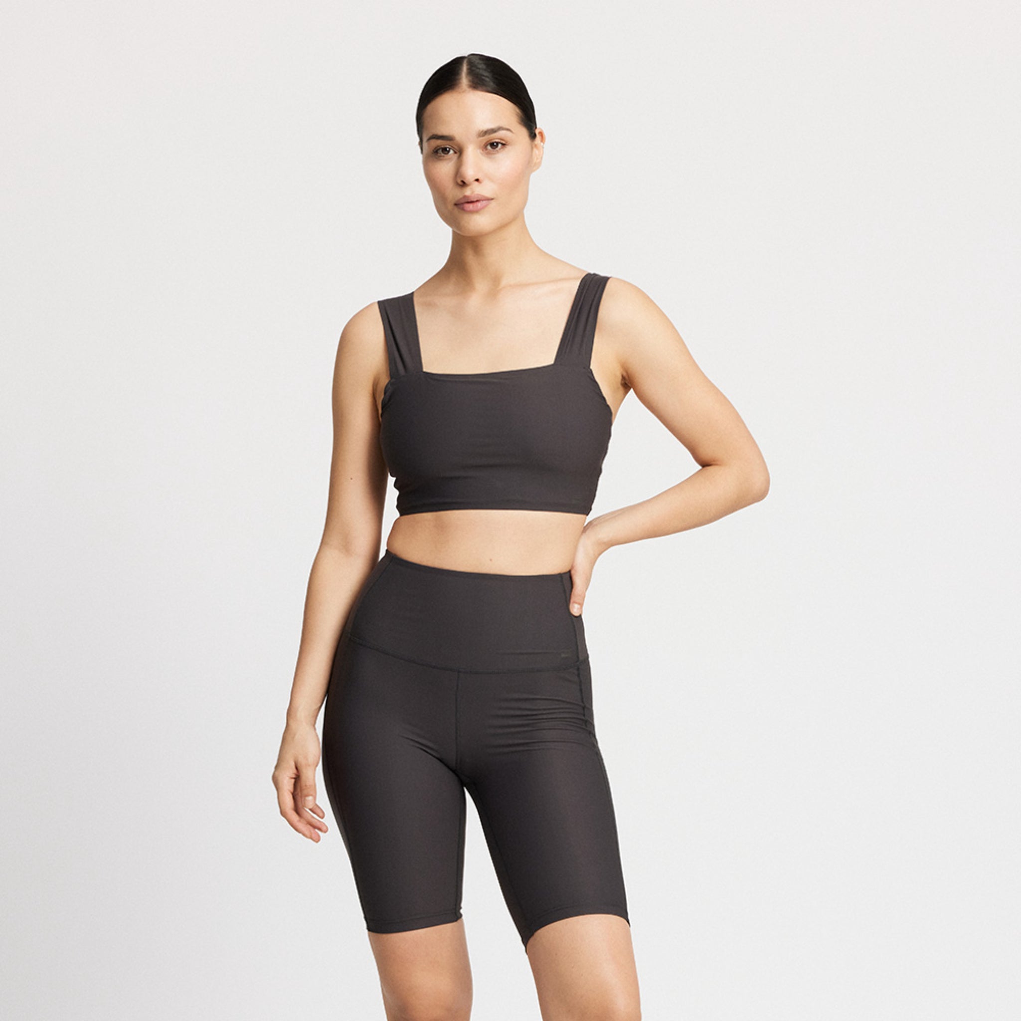Person in schwarzer Sportkleidung, bestehend aus einem crop top and shorts.