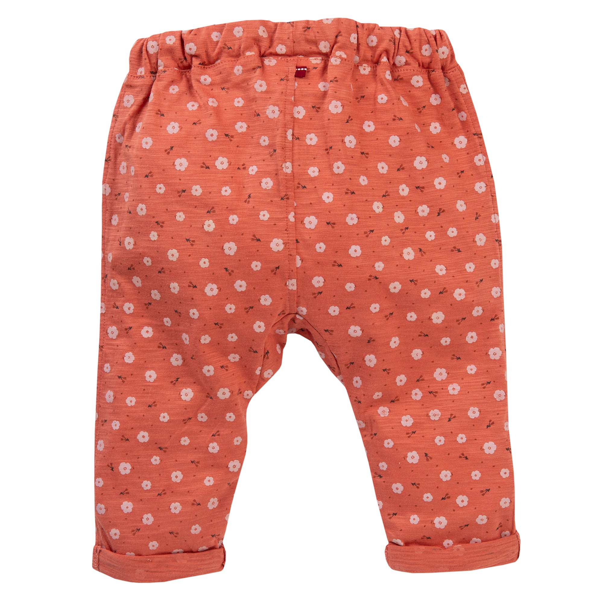 Orangefarbene Babyhose mit elastischem Bund und gerollten Bündchen, mit einem Muster aus kleinen weißen und rosa Blumen, die über den Stoff verstreut sind. Die Hose ist vor einem weißen Hintergrund abgebildet.