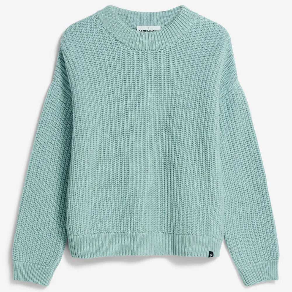 Hellblauer, langärmeliger, grob gestrickter Pullover mit geripptem Halsausschnitt, Bündchen und Saum. Der Pullover liegt flach auf einem einfarbig weißen Hintergrund.