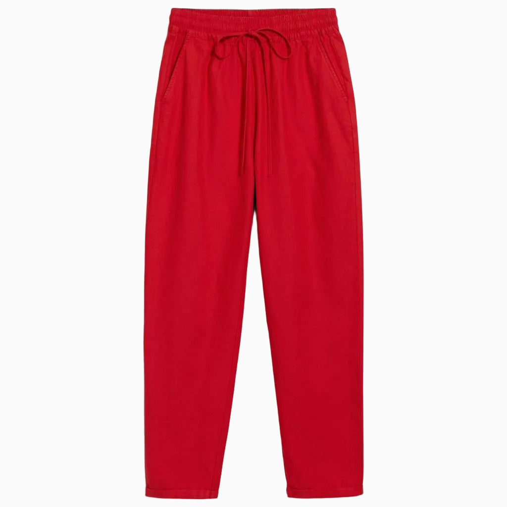 Leuchtend rote Freizeithose mit elastischem Bund und Kordelzug, zwei Seitentaschen und entspannten, geraden Beinen, flach auf weißem Hintergrund gelegt.