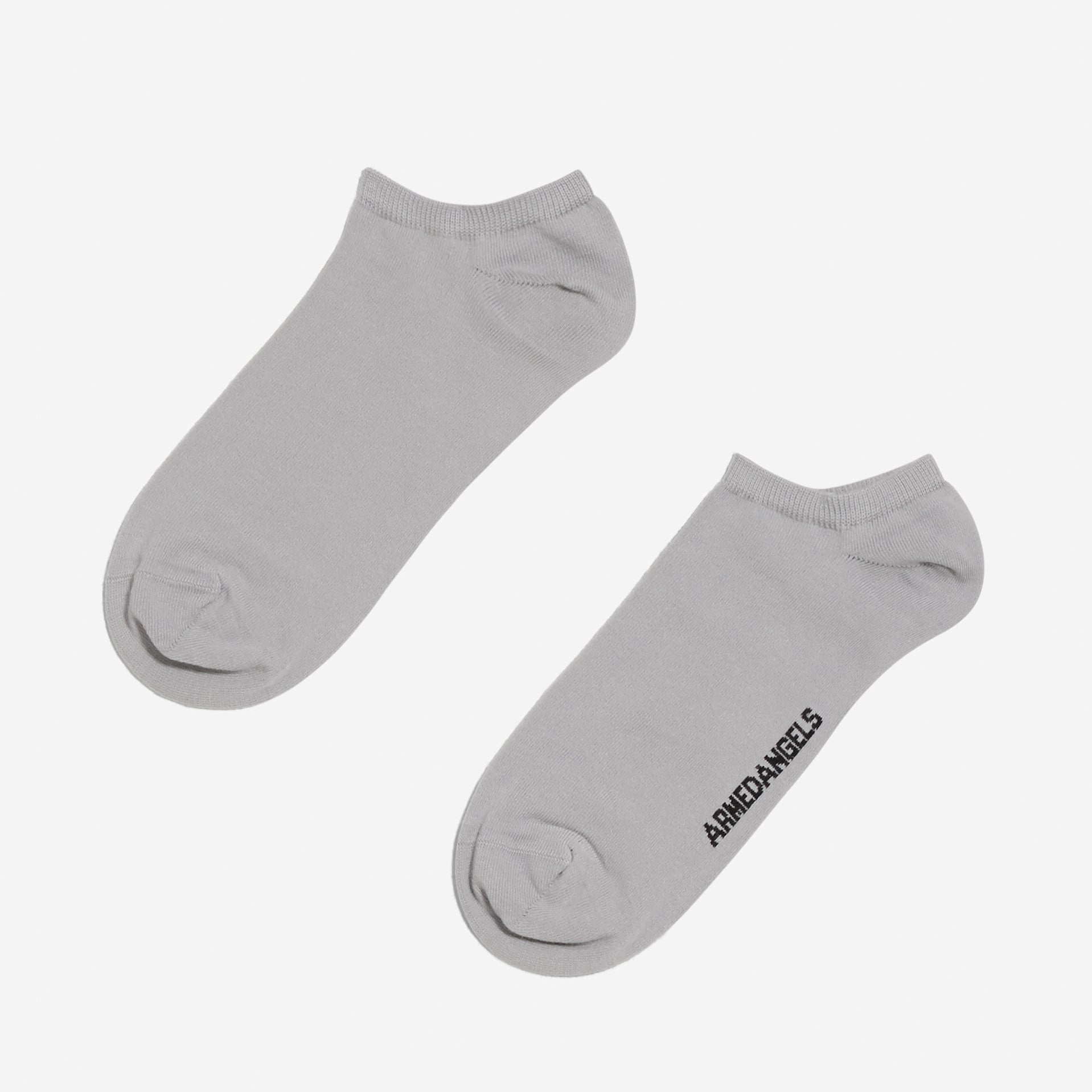 Graue Knöchelsocken mit Aufschrift "ANGEL" auf einer Socke, vor weißem Hintergrund.