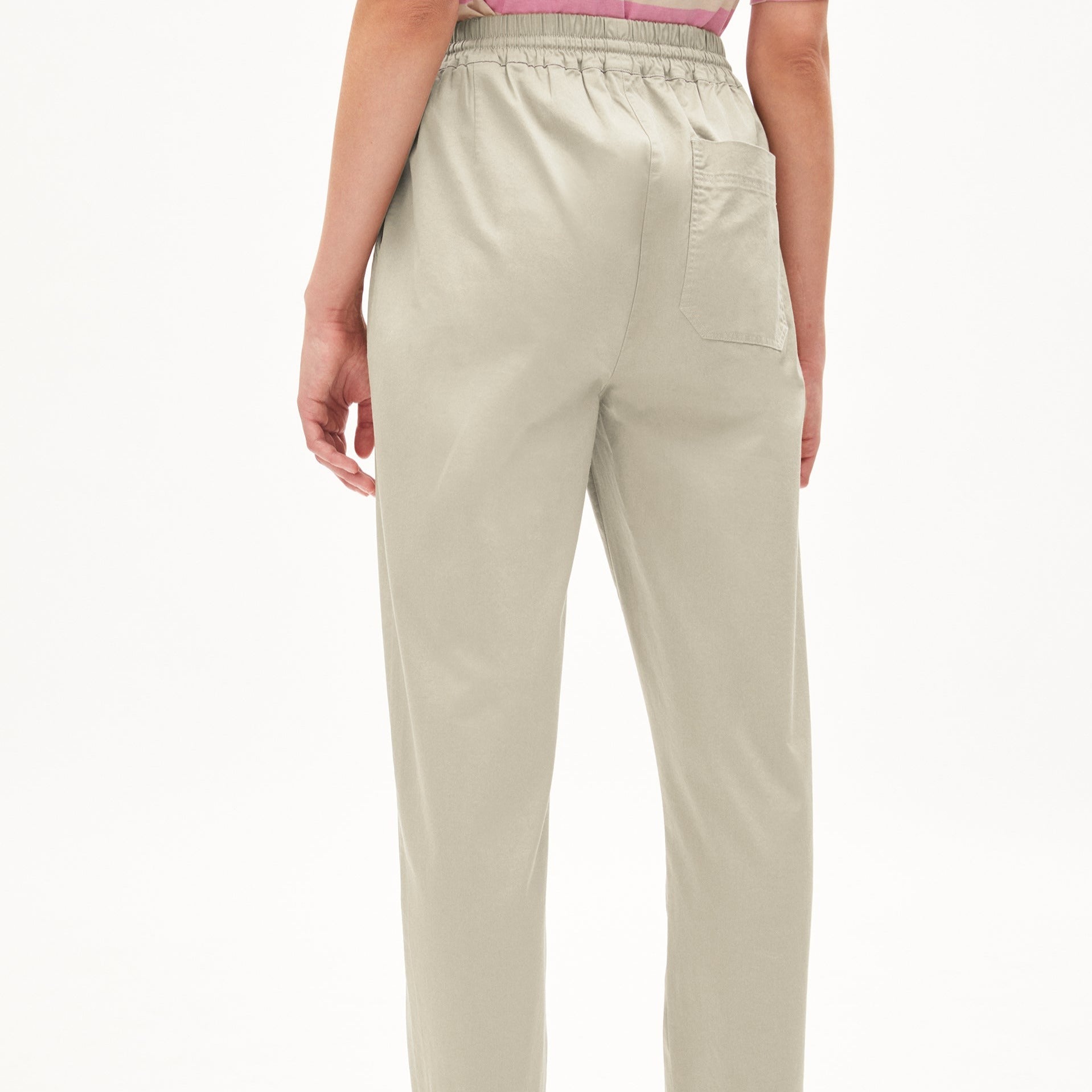 Person in beige pants with an elastic waistband, viewed from behind.