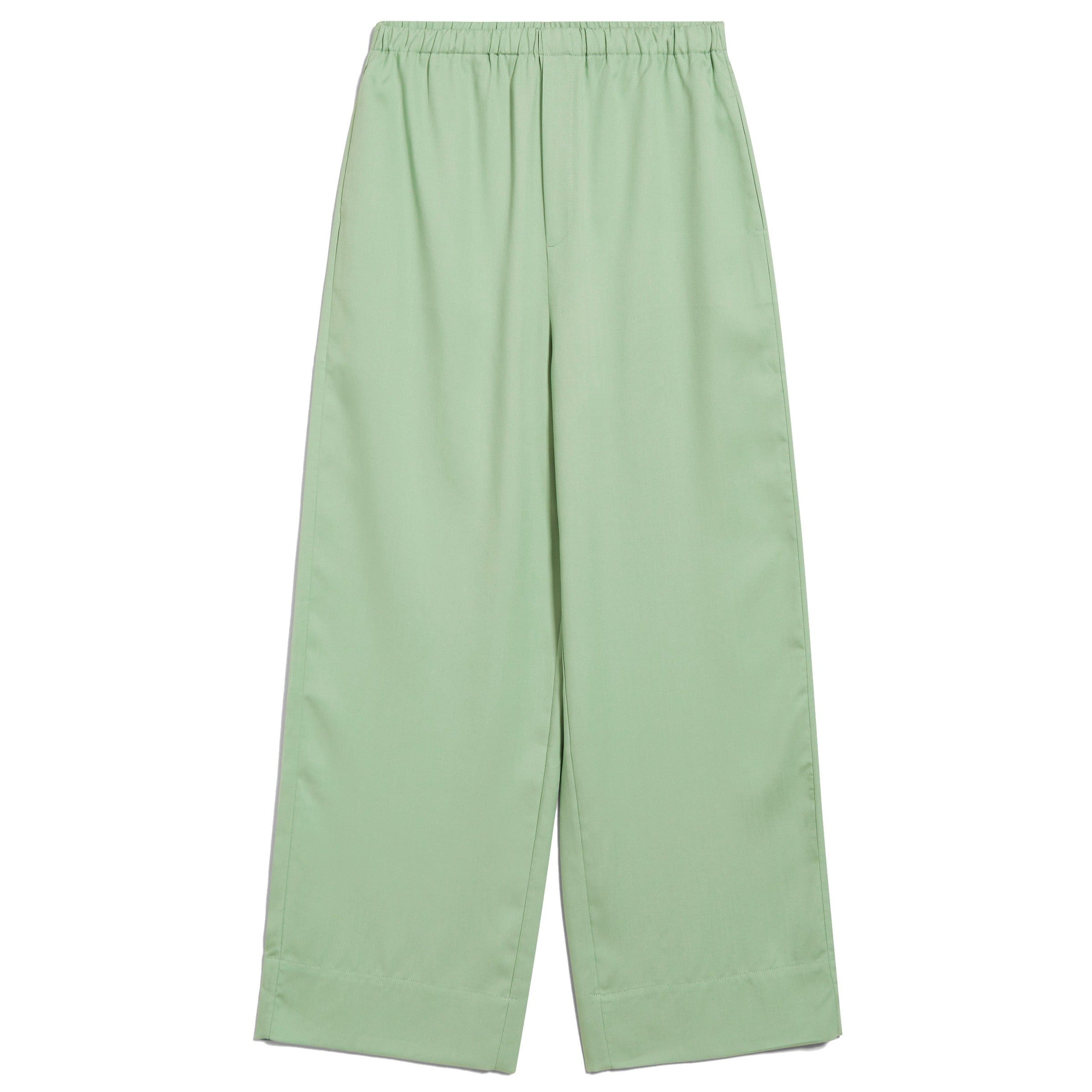 Hellgrüne, weite Hose mit elastischem Bund, auf einem weißen Hintergrund ausgebreitet.