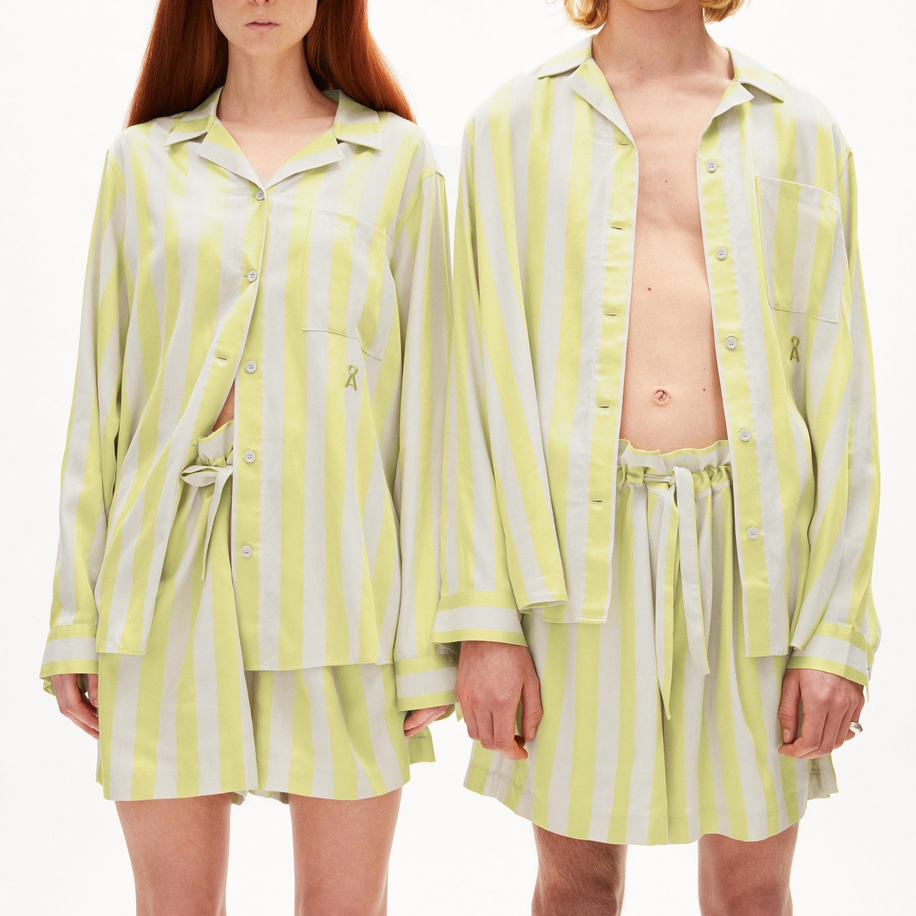Zwei Personen tragen locker sitzende Pyjamas in gelb-weiß gestreiftem Muster.