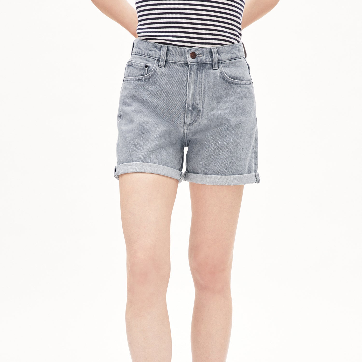 Person trägt eine graue Jeansshorts und ein gestreiftes Oberteil auf weißem Hintergrund.