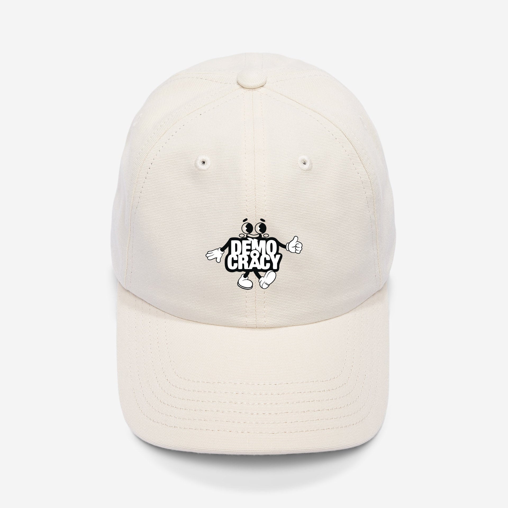 Eine cremefarbene Baseballkappe mit einer Cartoon-Figur und dem Text DEMO CRAZY, der auf die Vorderseite gestickt ist. Die Kappe ist auf einem schlichten weißen Hintergrund abgebildet.