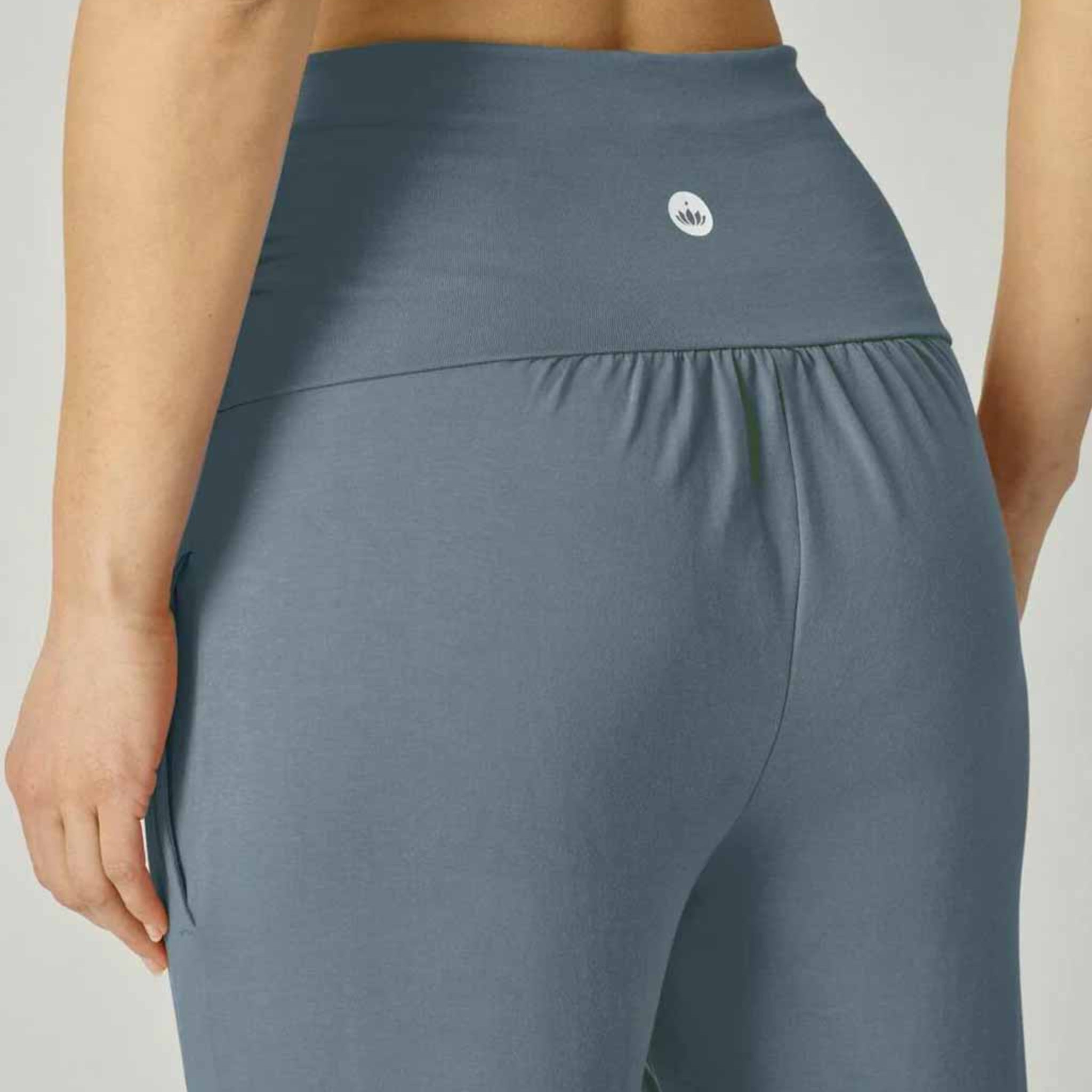 Rückansicht einer Person in einer grauen Sporthose mit einem kleinen Markenlogo auf der Taille.
