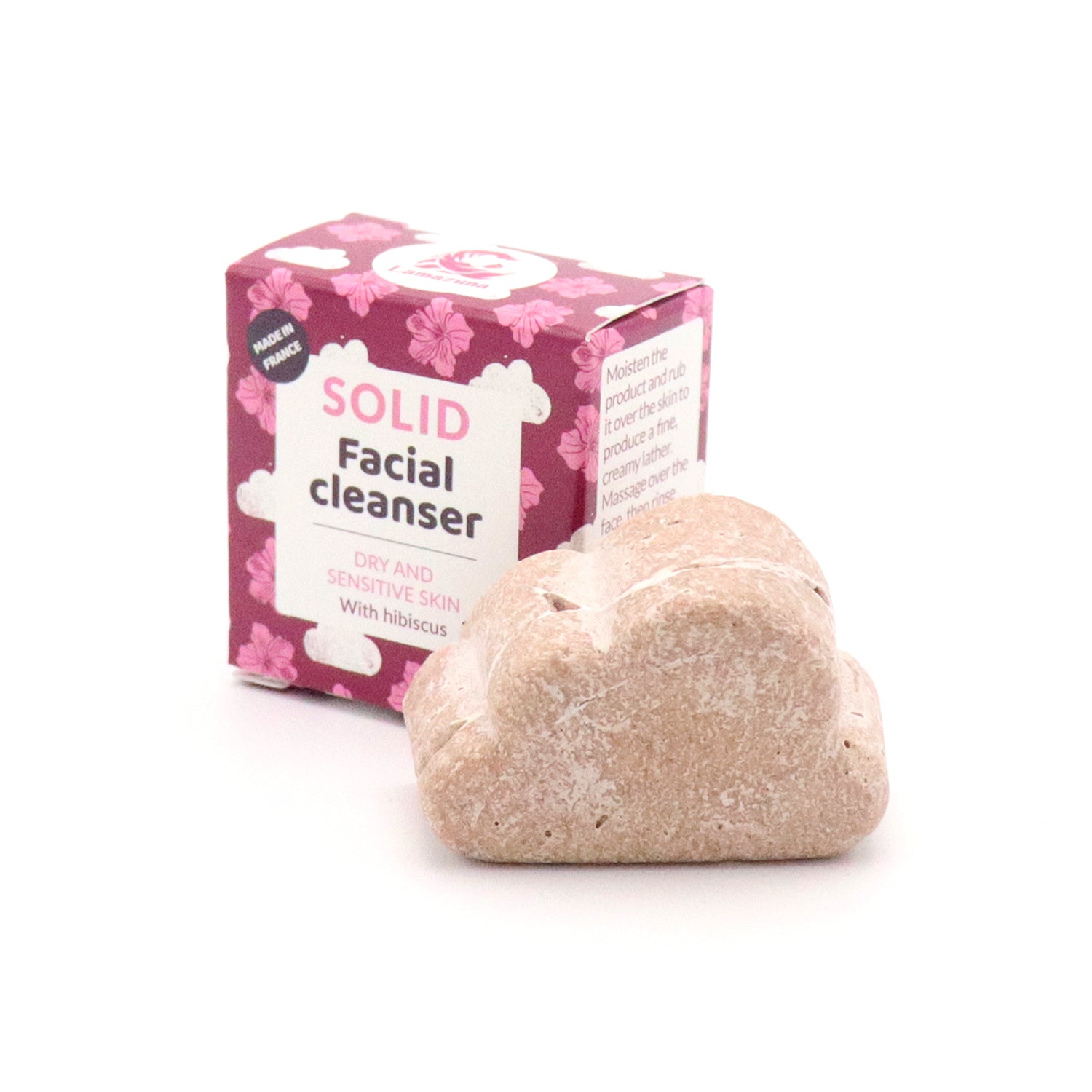 Ein fester Gesichtsreiniger in Wolkenform vor einer rosa Verpackung mit Blumenmuster für trockene und empfindliche Haut.