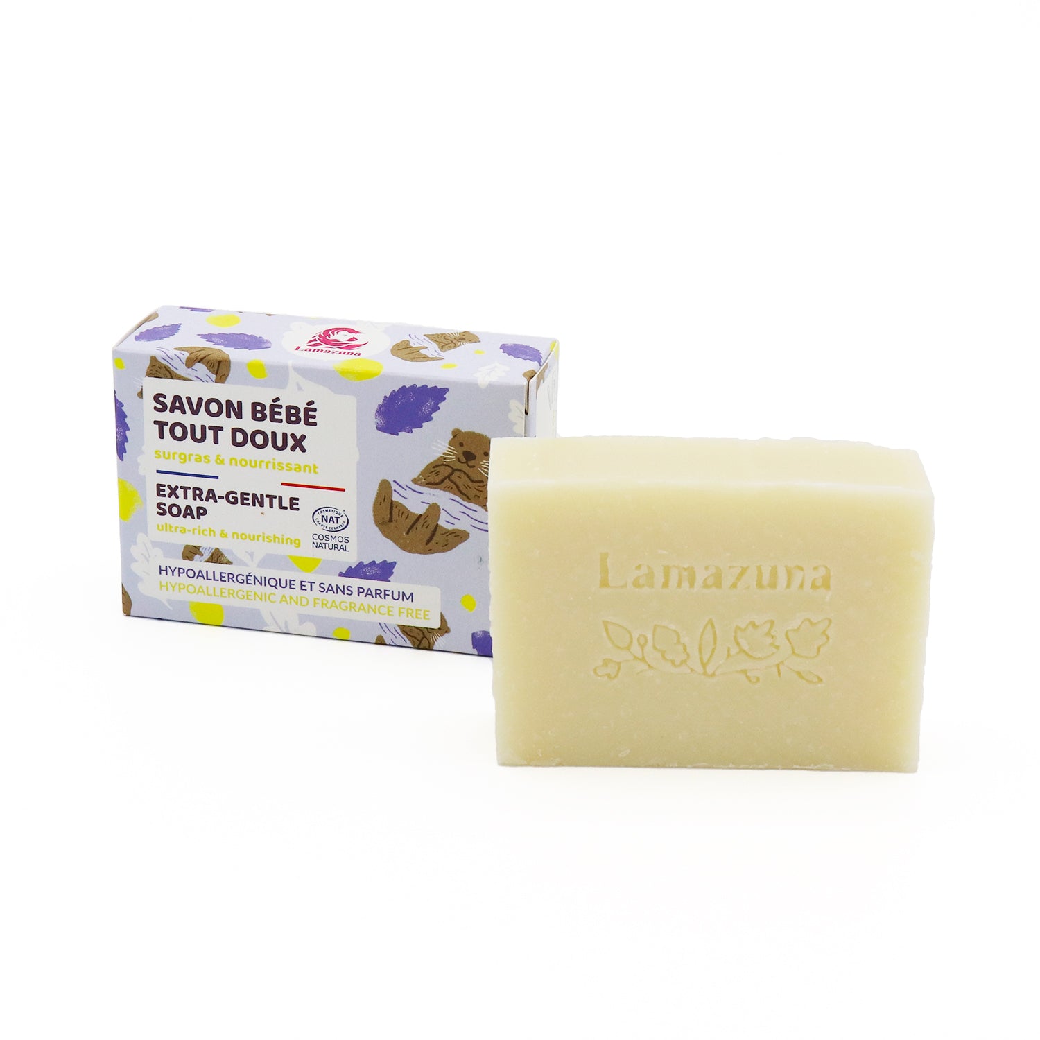 Eine hellbeige Seife mit der Prägung "Lamazuna" neben einer farbig bedruckten Verpackung mit der Aufschrift "Savon Bébé".