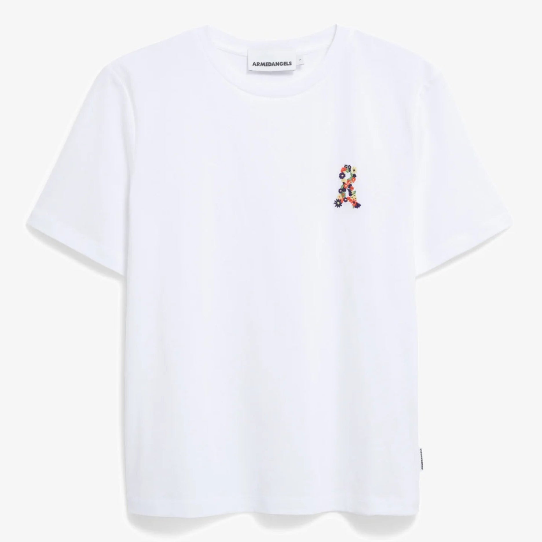 Ein schlichtes, weißes, kurzärmeliges T-Shirt mit einem kleinen, bunten, aufgestickten Motiv auf der linken Brustseite vor einem hellgrauen Hintergrund.