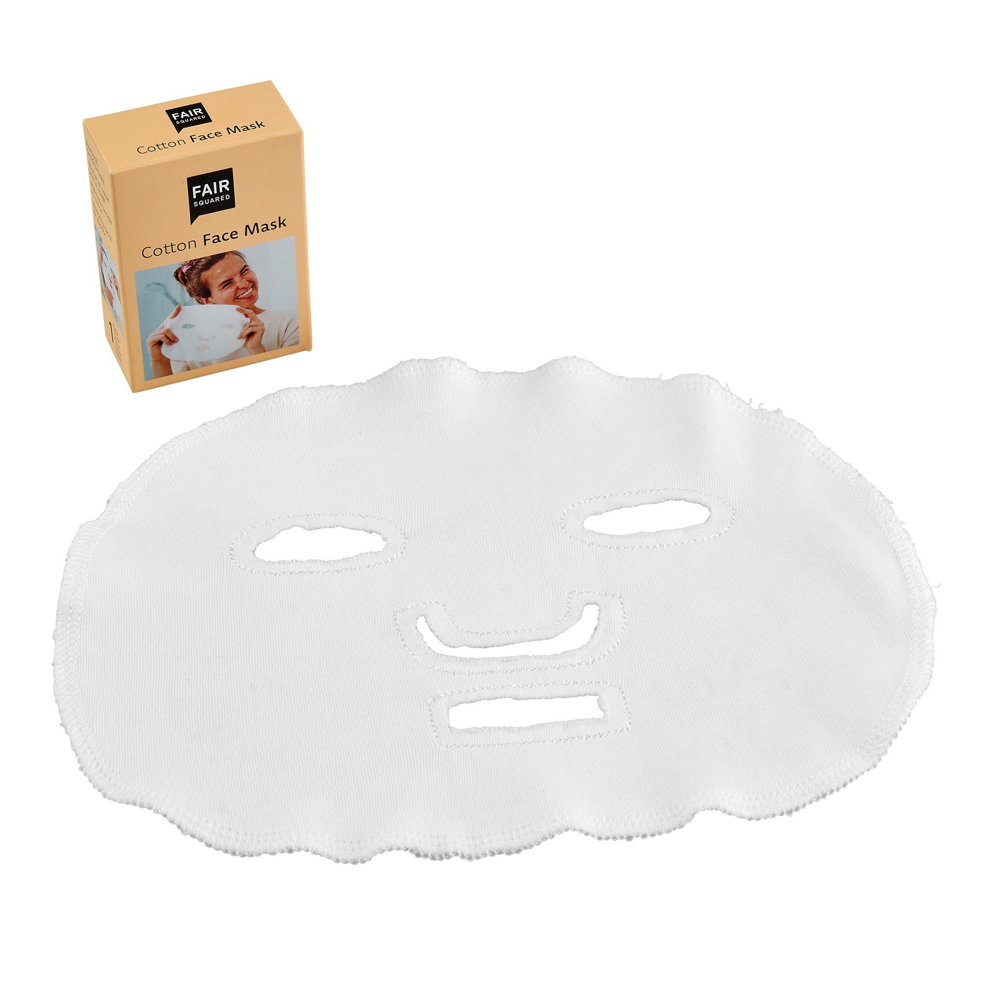 Eine weiße Gesichtsmaske aus Baumwolle mit Aussparungen für Augen, Nase und Mund wird neben der Verpackungsschachtel mit der Aufschrift FAIR Cotton Face Mask ausgestellt, auf der das Bild einer lächelnden Person zu sehen ist, die die Maske hält.