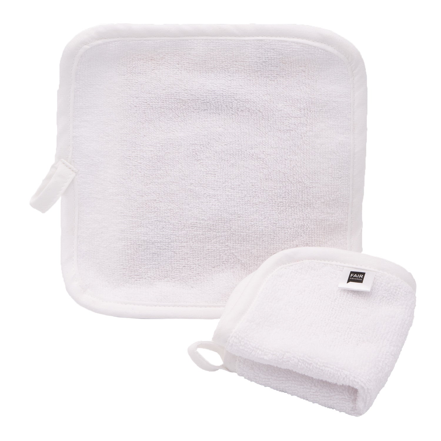 Ein weißer quadratischer Waschlappen mit abgerundeten Ecken und einer Aufhängeschlaufe neben einem weißen Frottee-Badehandtuch, beide auf einem schlichten weißen Hintergrund.