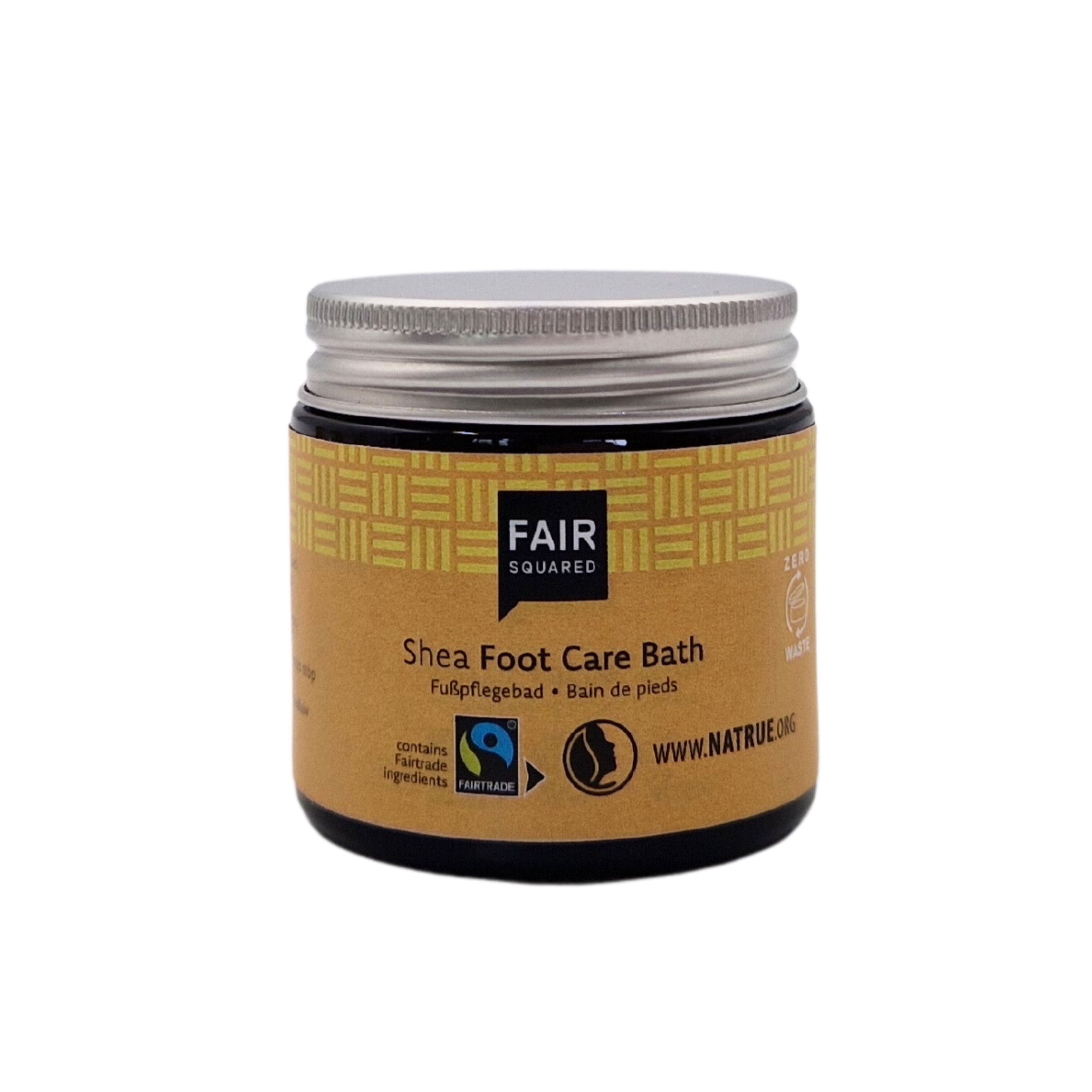 Ein Tiegel Fair Squared Shea Foot Care Bath mit einem silbernen Deckel und einem beigen Etikett mit Produktangaben, Zertifizierungslogos und der Website www.natrue.org.