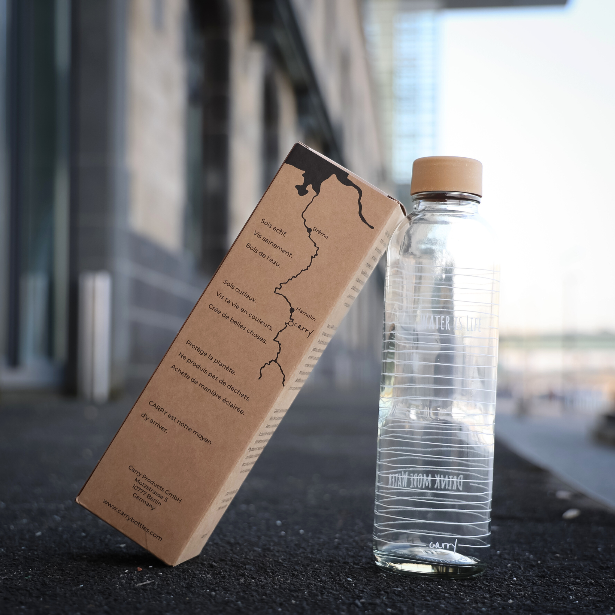 Ein Wasserglasflasche mit einer braunen Verpackung auf einem Bürgersteig vor einem Gebäude.