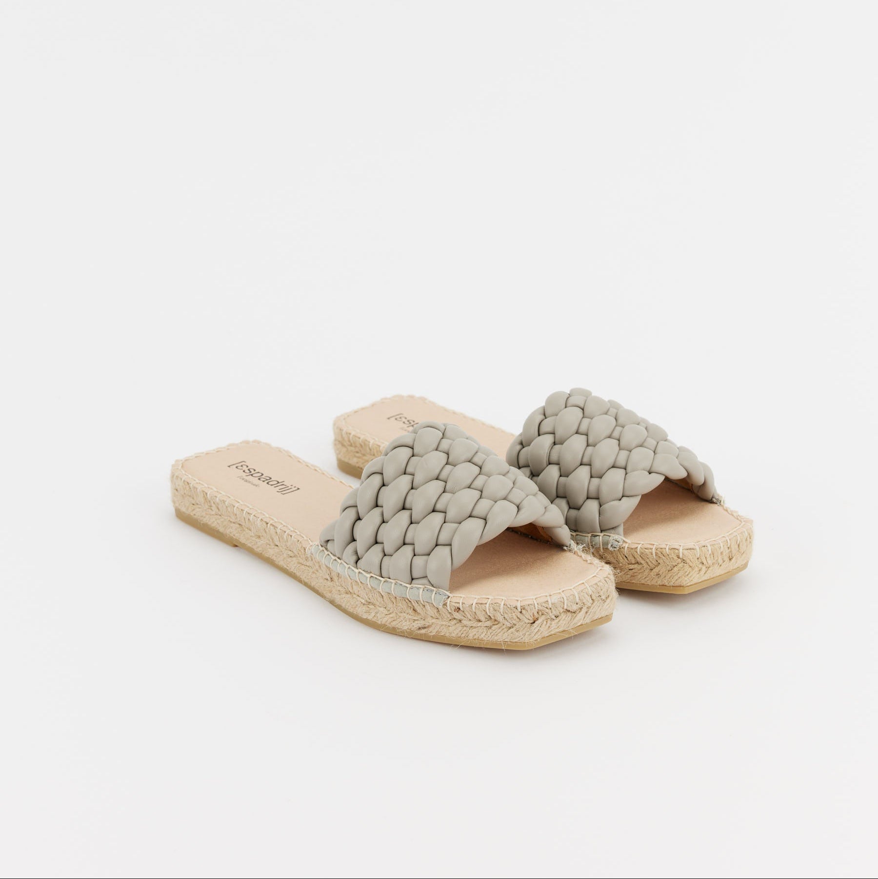 Zwei graue, geflochtene Sandalen mit Bastsohle auf weißem Hintergrund.