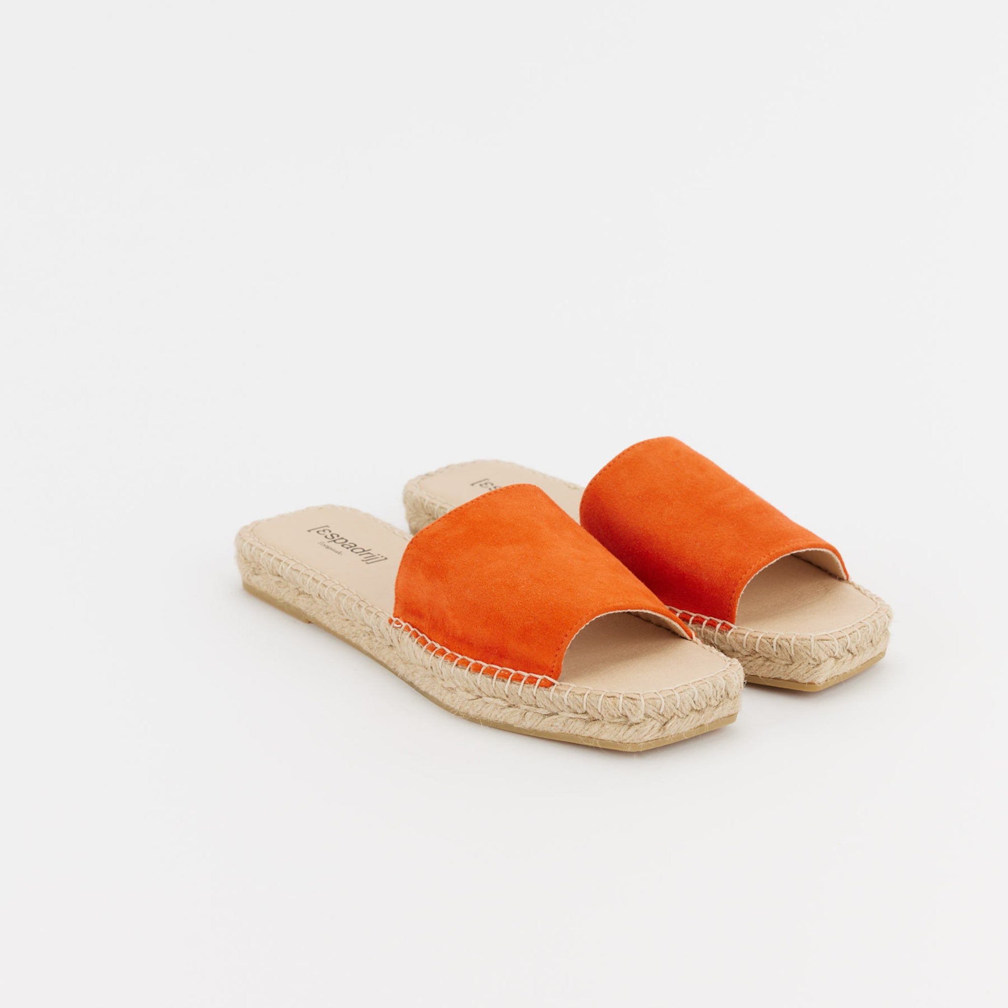 Orangefarbene Sandalen mit geflochtener Sohle auf weißem Hintergrund.