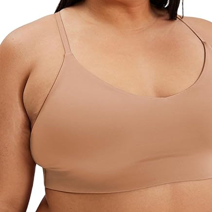 Eine Frau trägt einen nudefarbenen, nahtlosen Bralette mit dünnen Trägern und blickt leicht zur Seite. Das Bild ist so beschnitten, dass sie von der Brust aufwärts zu sehen ist.