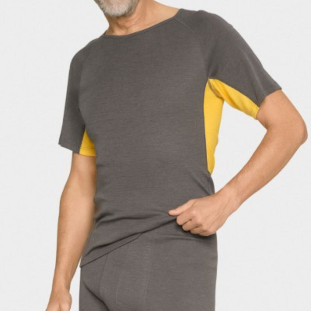 Ein Mann, der ein kurzärmeliges, dunkelgraues Hemd mit gelben Seitenteilen und eine dazu passende graue Hose trägt, posiert vor einem schlichten hellen Hintergrund.