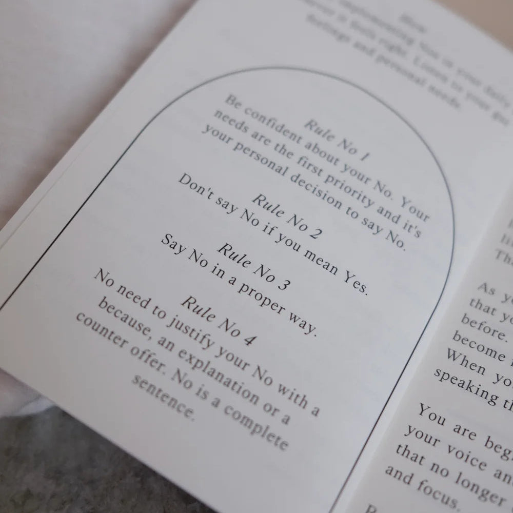 Eine Nahaufnahme eines aufgeschlagenen Büchleins mit vier Regeln für das Neinsagen, die Vertrauen, Ehrlichkeit und die Tatsache betonen, dass es keiner Erklärung oder Rechtfertigung bedarf, wenn man eine Bitte ablehnt.