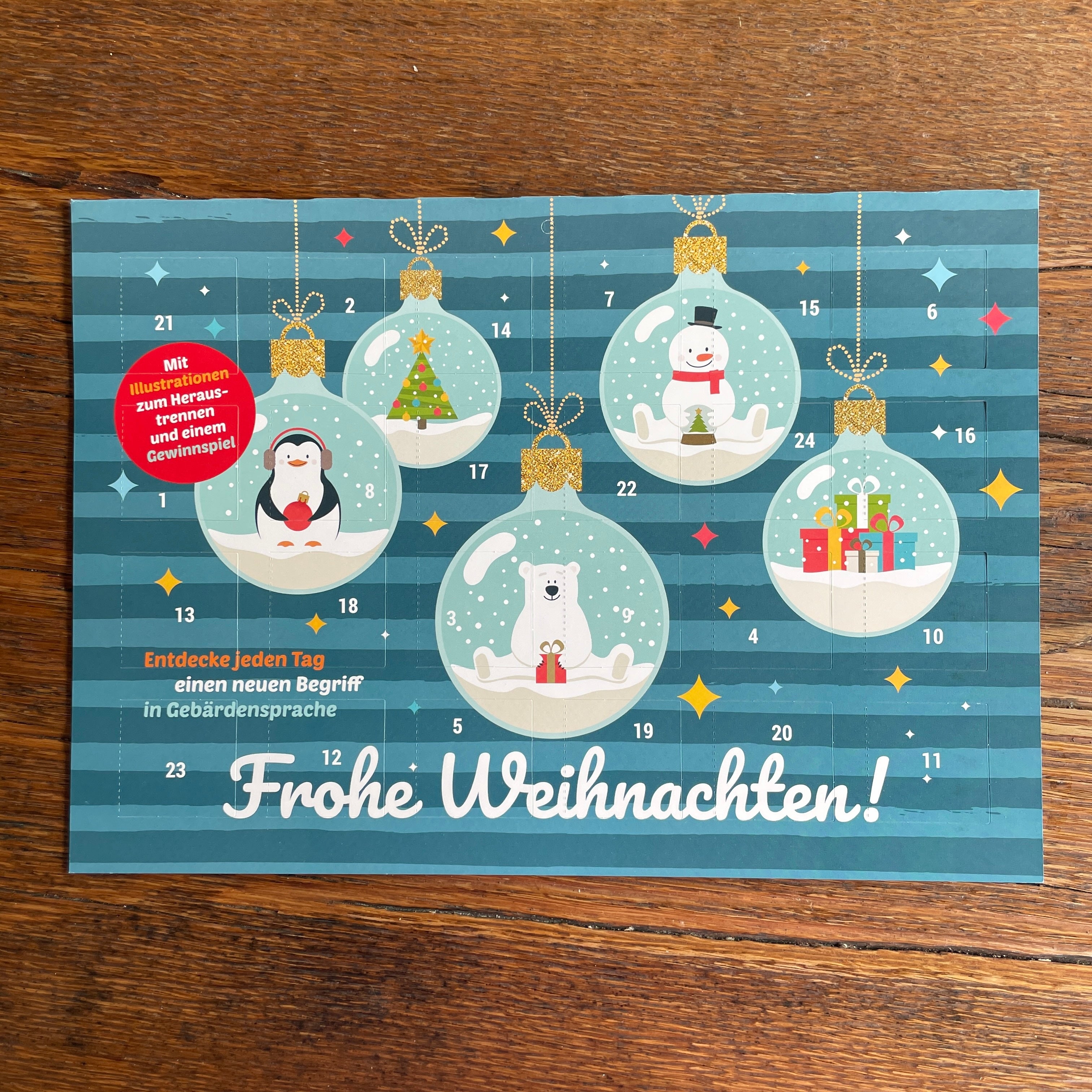 Ein deutscher Adventskalender mit festlichen Illustrationen eines Pinguins, Schneemanns, Eisbären und Rentiers in Ornamenten auf blau gestreiftem Hintergrund. Der Text lautet "Frohe Weihnachten!" und fördert das Erlernen der Gebärdensprache.
