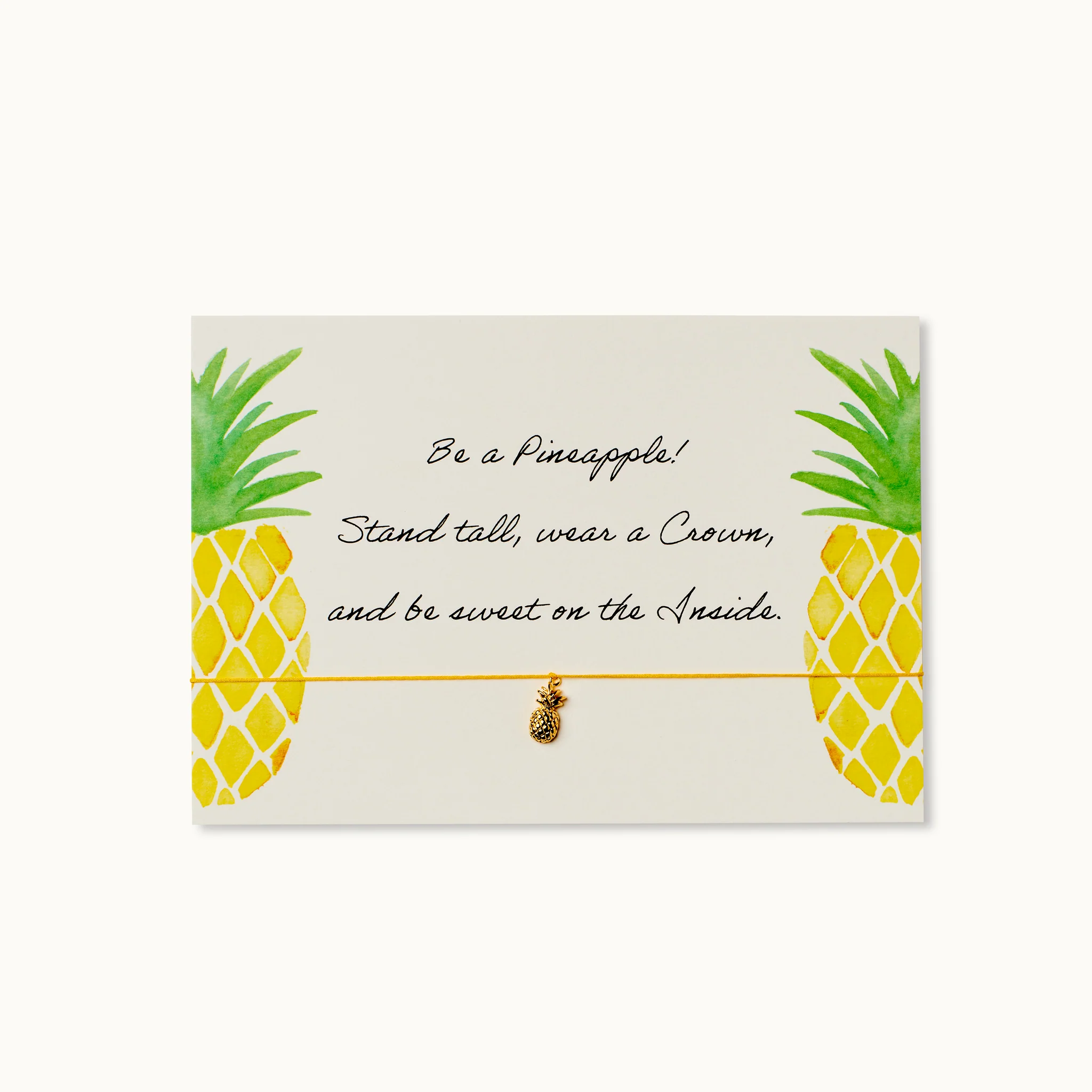 Karte mit Ananasgrafik, einem Spruch über Ananas und einem goldenen Ananasanhänger an einem gelben Band.