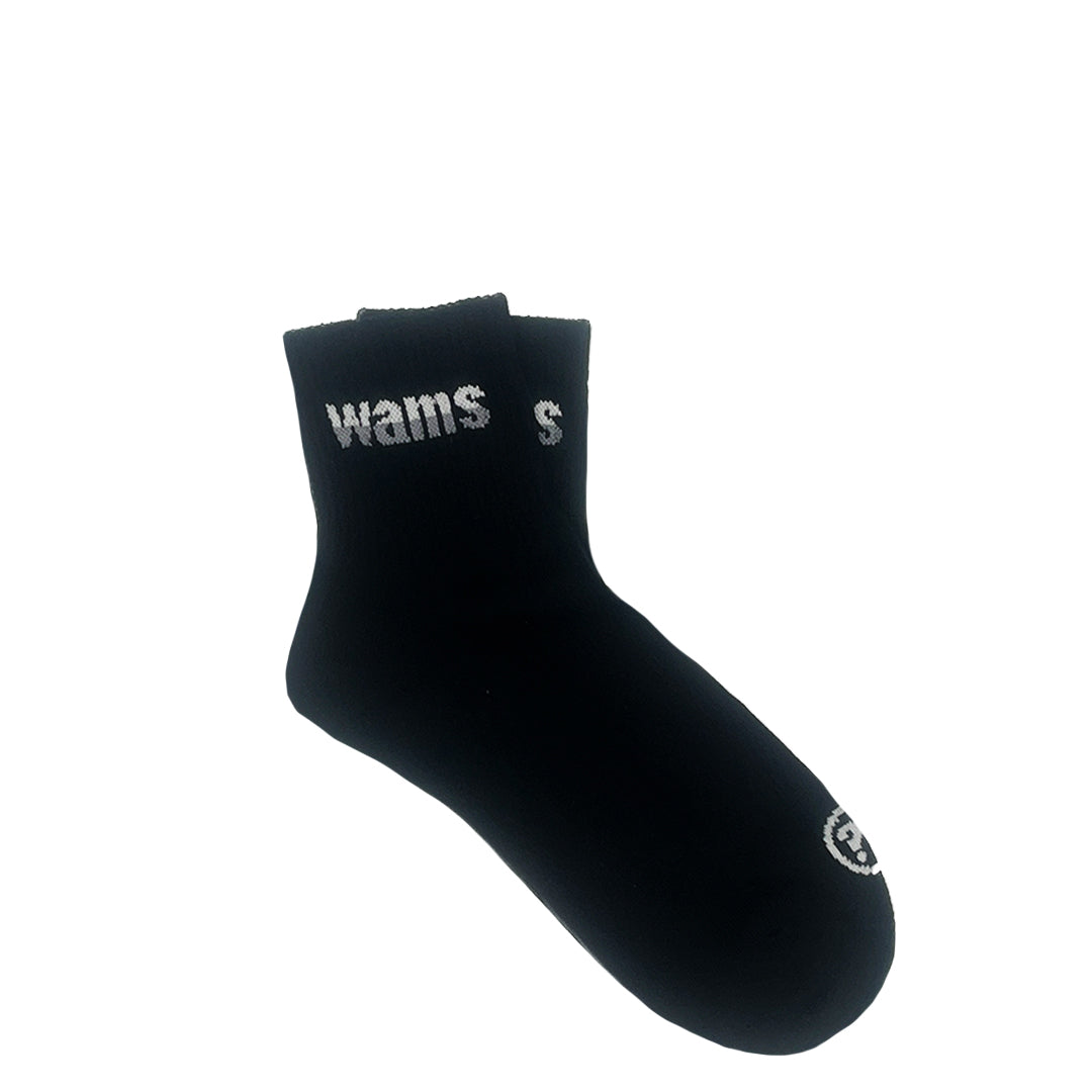 Schwarze Socke mit weißem Schriftzug "wams" und kleinem rundem Logo vorne, auf weißem Hintergrund.