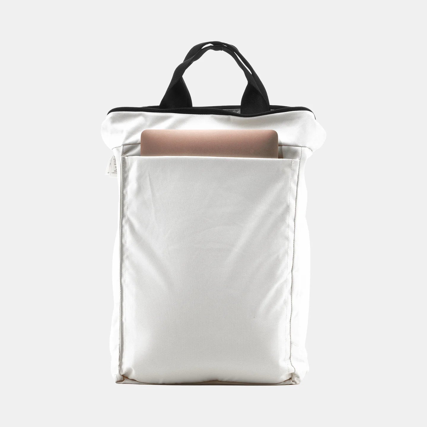 Ein weißer Rucksack mit schwarzen Griffen, aus dessen offene Tasche ein Laptop hervorschaut, vor grauem Hintergrund.