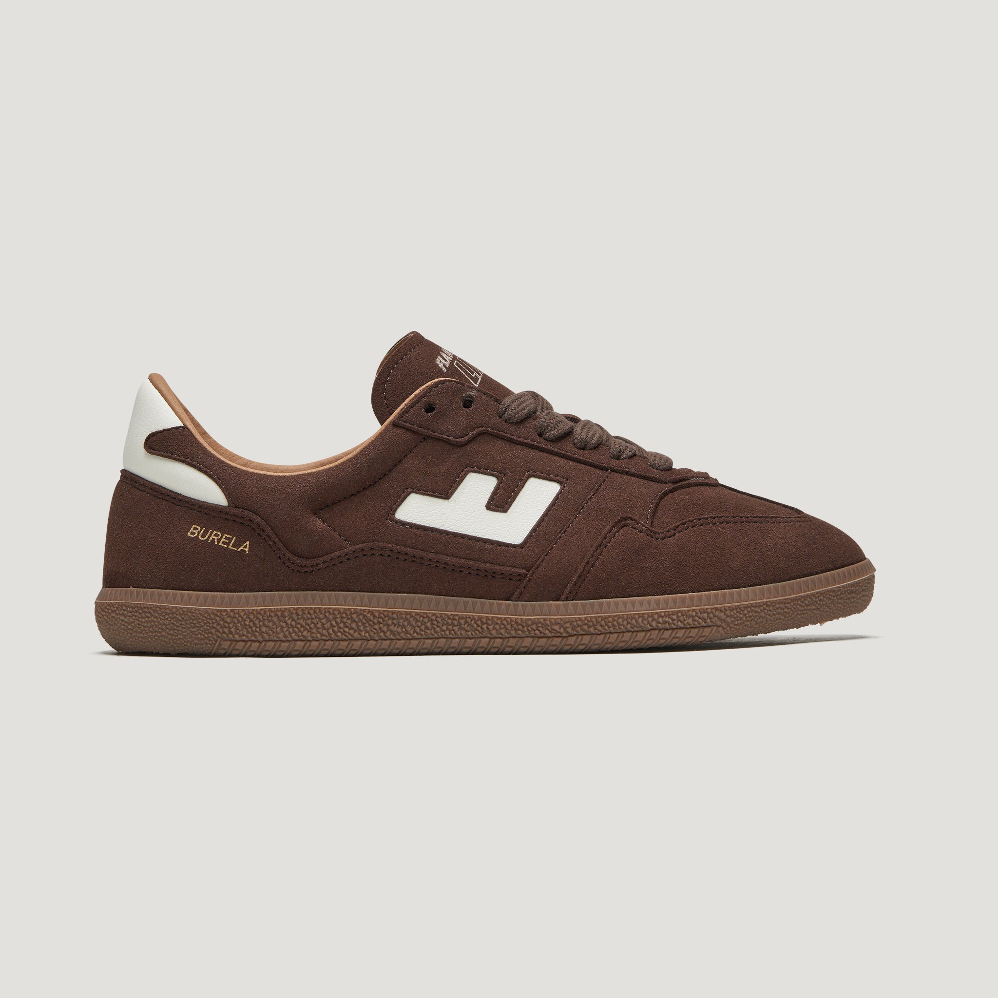 Brauner Sneaker mit weißem Logo und hellem Profil auf weißem Hintergrund, seitlich abgebildet.