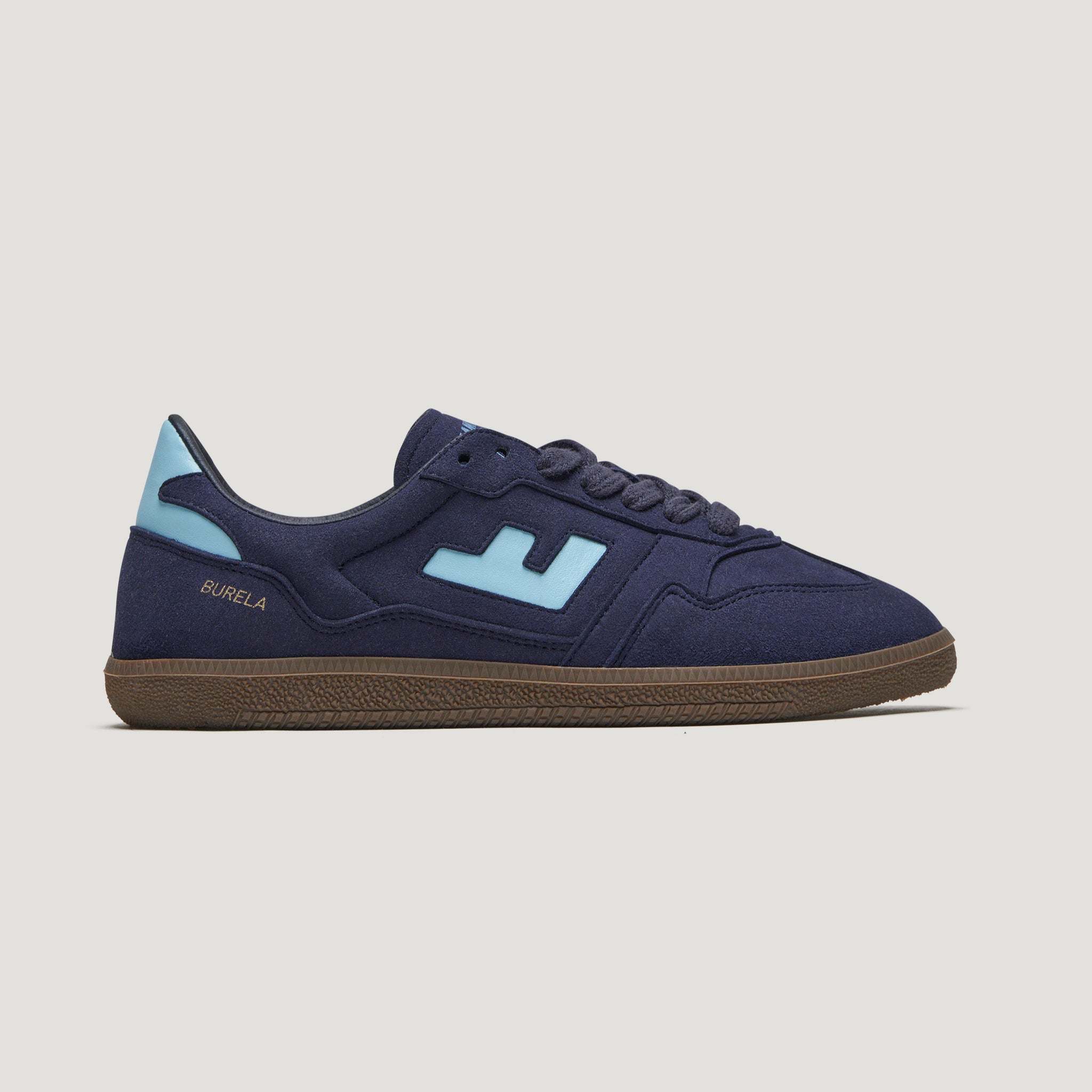 Dunkelblauer Sneaker mit hellblauen Akzenten und brauner Sohle, seitlich mit dem Wort "Burela" und einem stilisierten Logo.