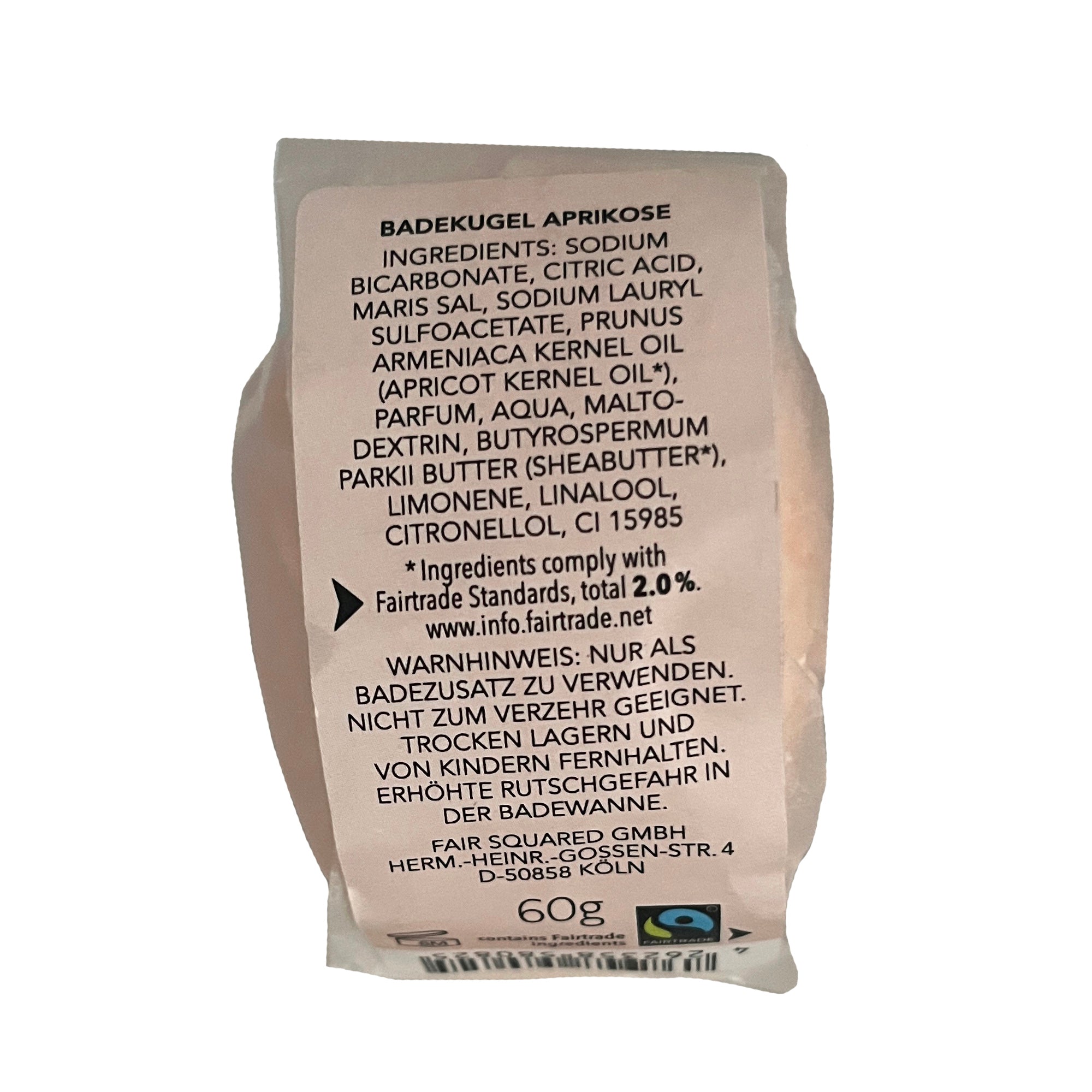 Auf dem Produktetikett einer Aprikosen-Badebombe sind die Inhaltsstoffe und die Gebrauchsanweisung in deutscher Sprache aufgeführt, ebenso wie die Fairtrade-Zertifizierung und das Nettogewicht von 60 g. Das Etikett enthält außerdem ein Fairtrade-Logo und Informationen zum Unternehmen.