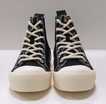 Ein Paar schwarze High-Top-Sneaker mit weißen Schnürsenkeln und heller Sohle ist frontal zu sehen.