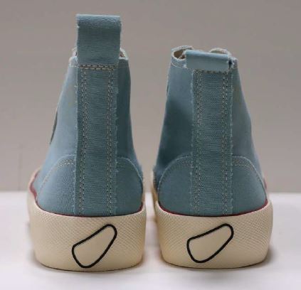 Zwei hellblaue Stoffschuhe mit cremefarbenen Sohlen und einzigartigem schwarzen Detail an den Fersen, von hinten gesehen.