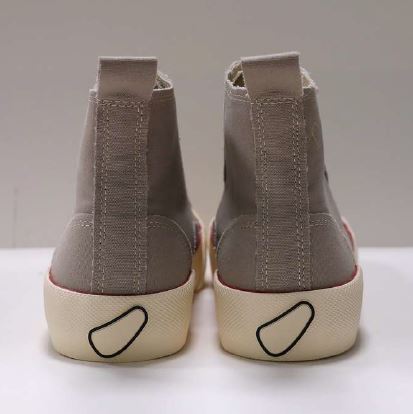 Graue, knöchelhohe Sneaker von hinten mit cremefarbenen Sohlen und einem schwarzen Design-Element an der Ferse.