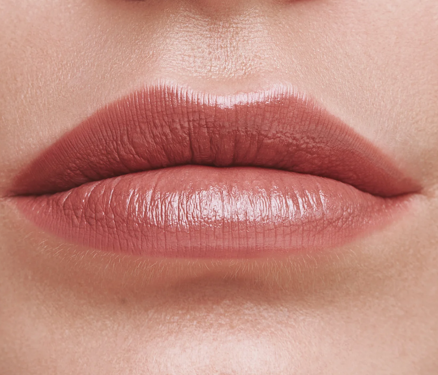 Nahaufnahme von glänzend rosa geschminkten Lippen.