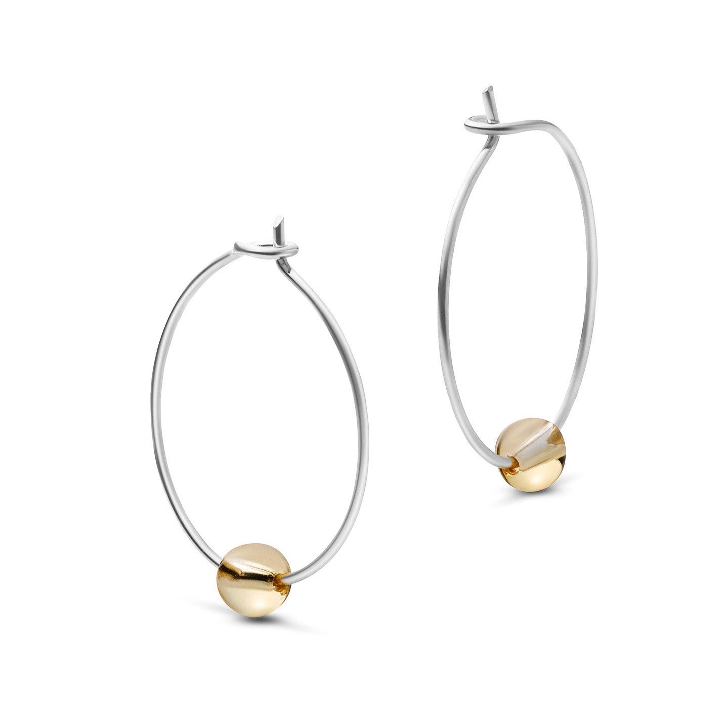 Silberne Creolen mit einer goldenen Kugel als Ornament.