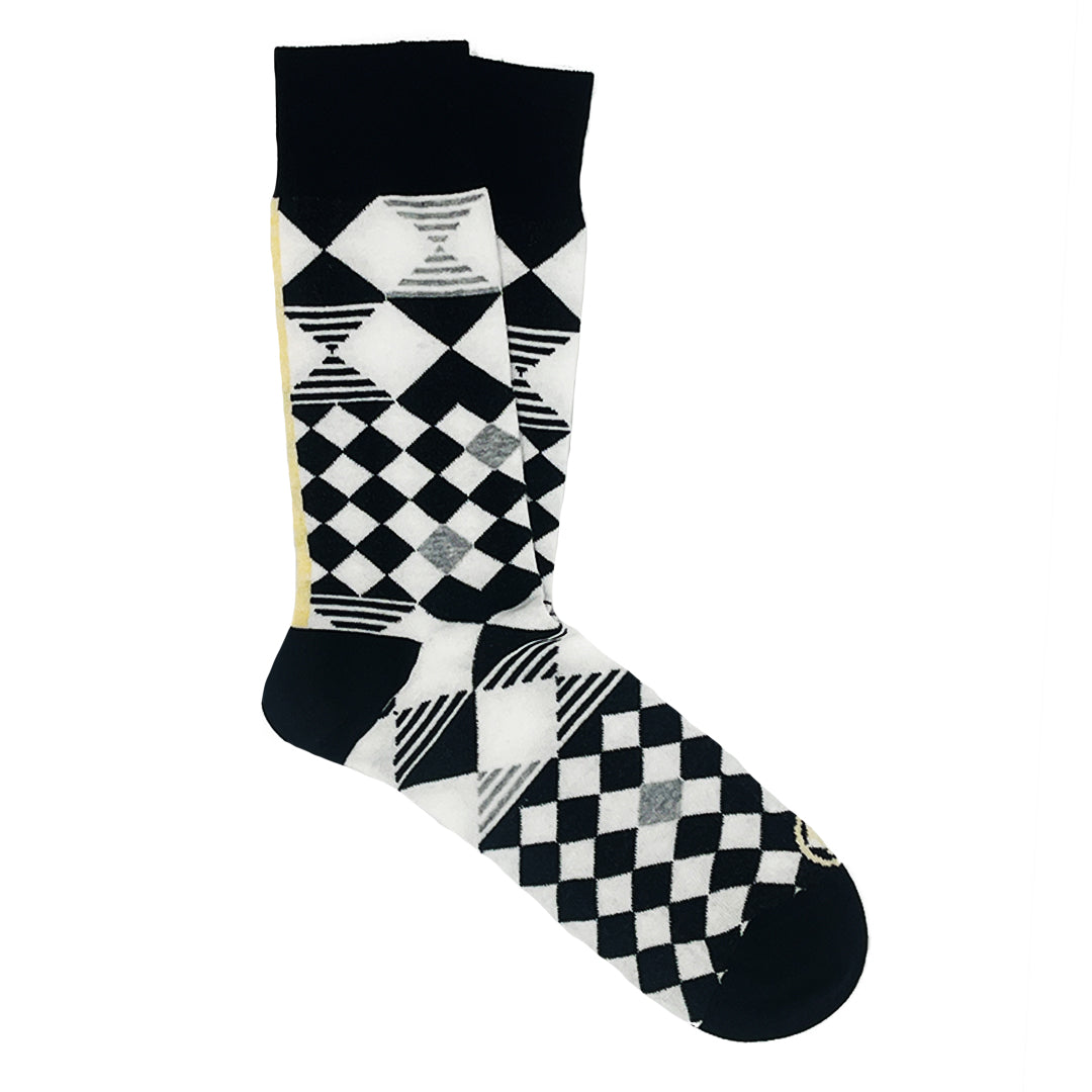 Schwarz-weiße Socke mit geometrischen Mustern wie Rauten und Quadraten auf weißem Hintergrund.