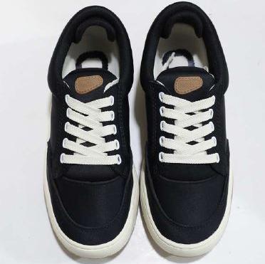 Schwarze Sneakers mit weißen Schnürsenkeln und heller Sohle auf weißem Hintergrund.